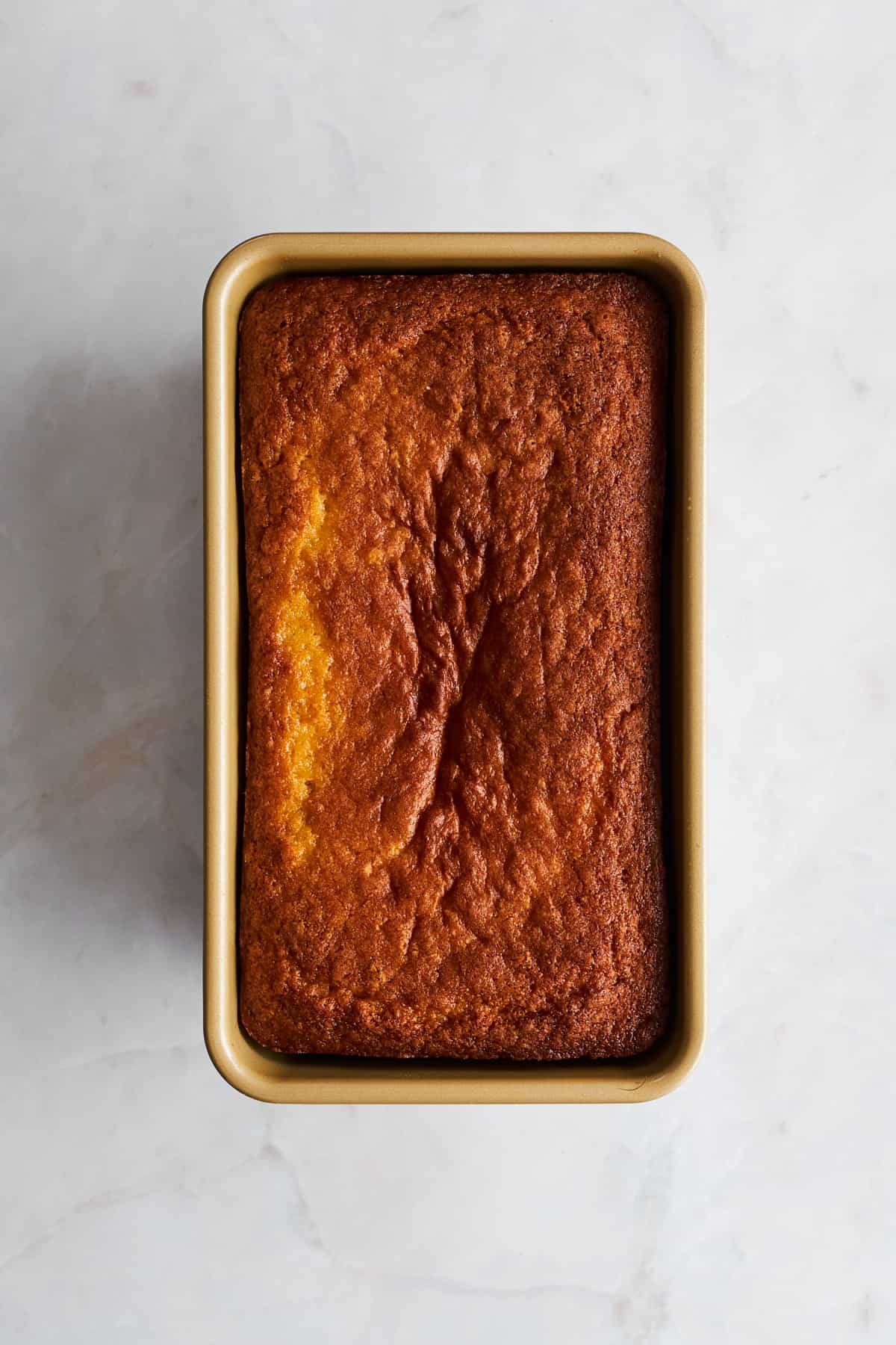 Baked lemon loaf in a loaf pan.