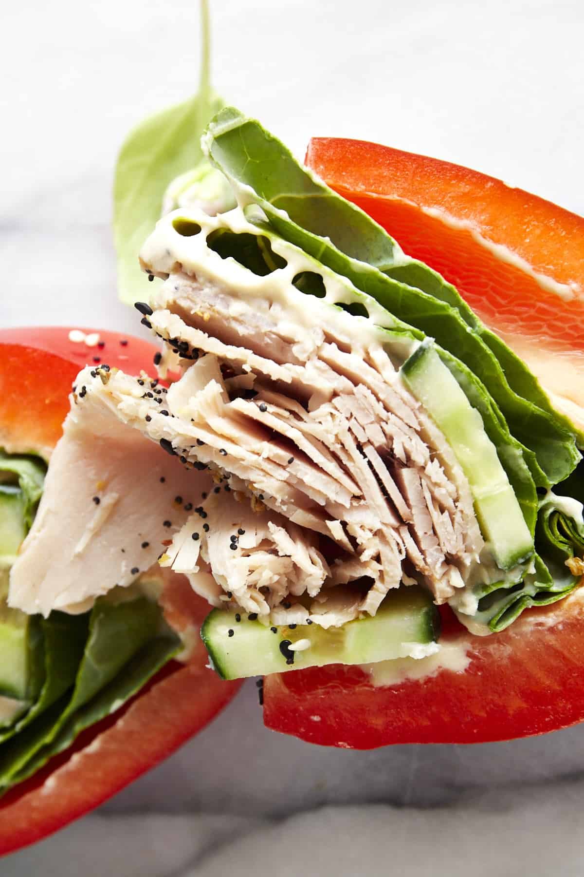 Close up image of a turkey bell pepper sandwich half topped with everything but the bagel seasoning.