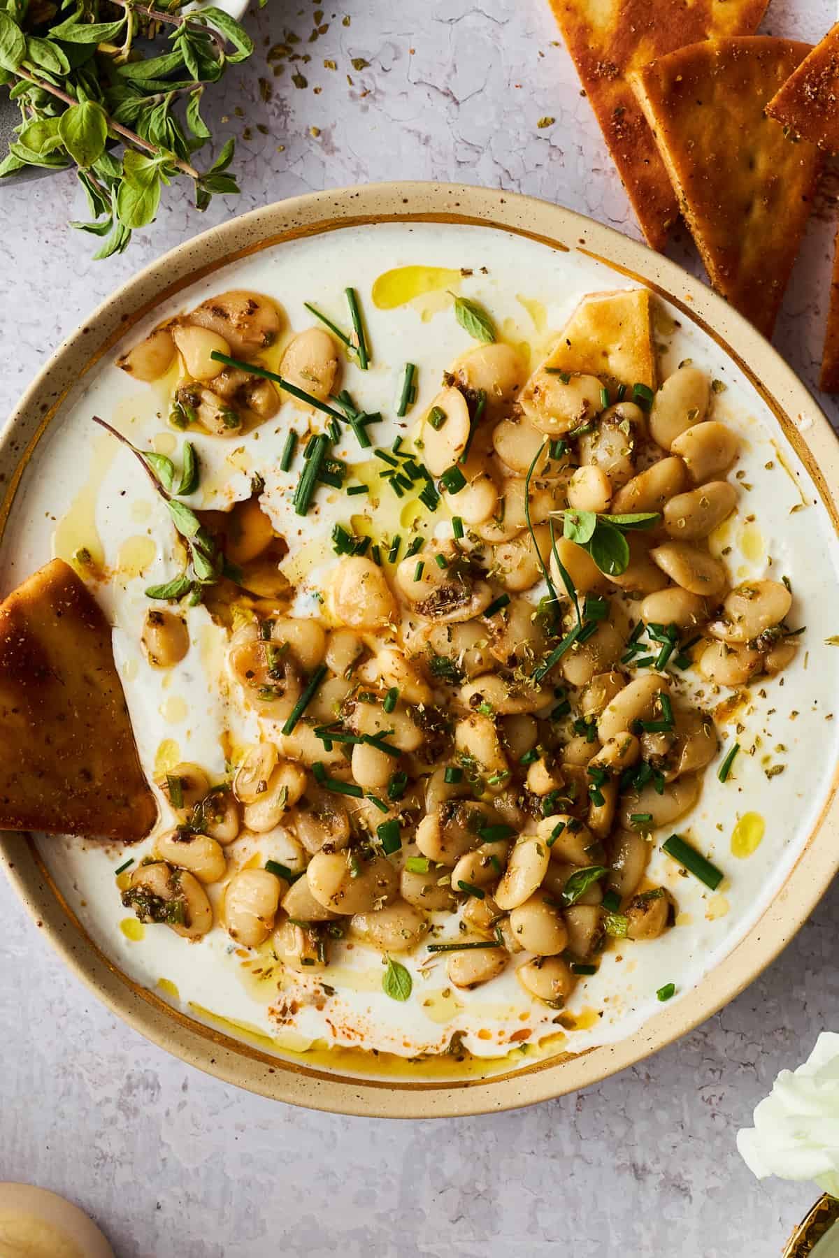 Marinated butter beans with whipped cottage cheese and a pita chip on the side.
