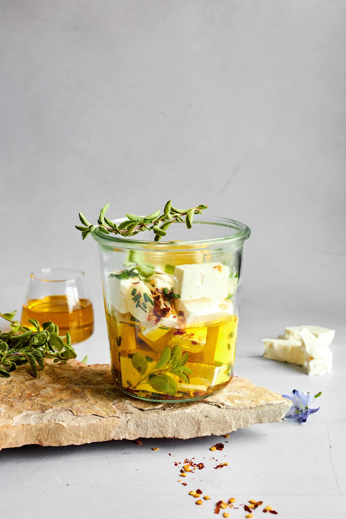 Feta cubes being soaked in an olive oil marinade.