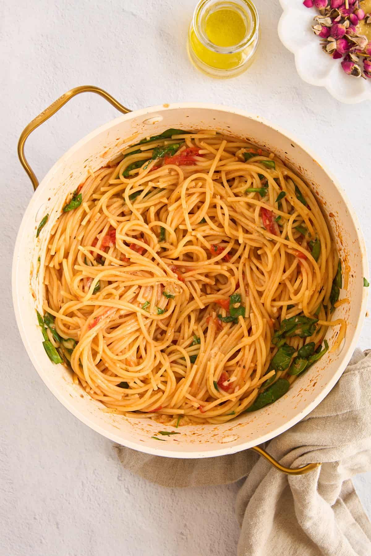 A pot of cooked Meghan Markle pasta with spinach and tomatoes.