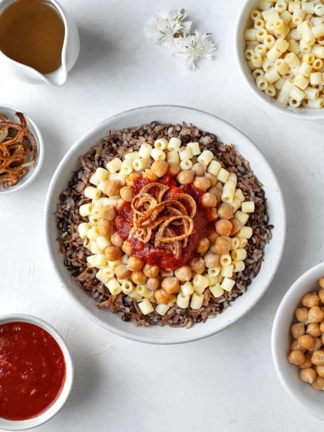 overhead large bowl of koshari with the fixings on top and the sides