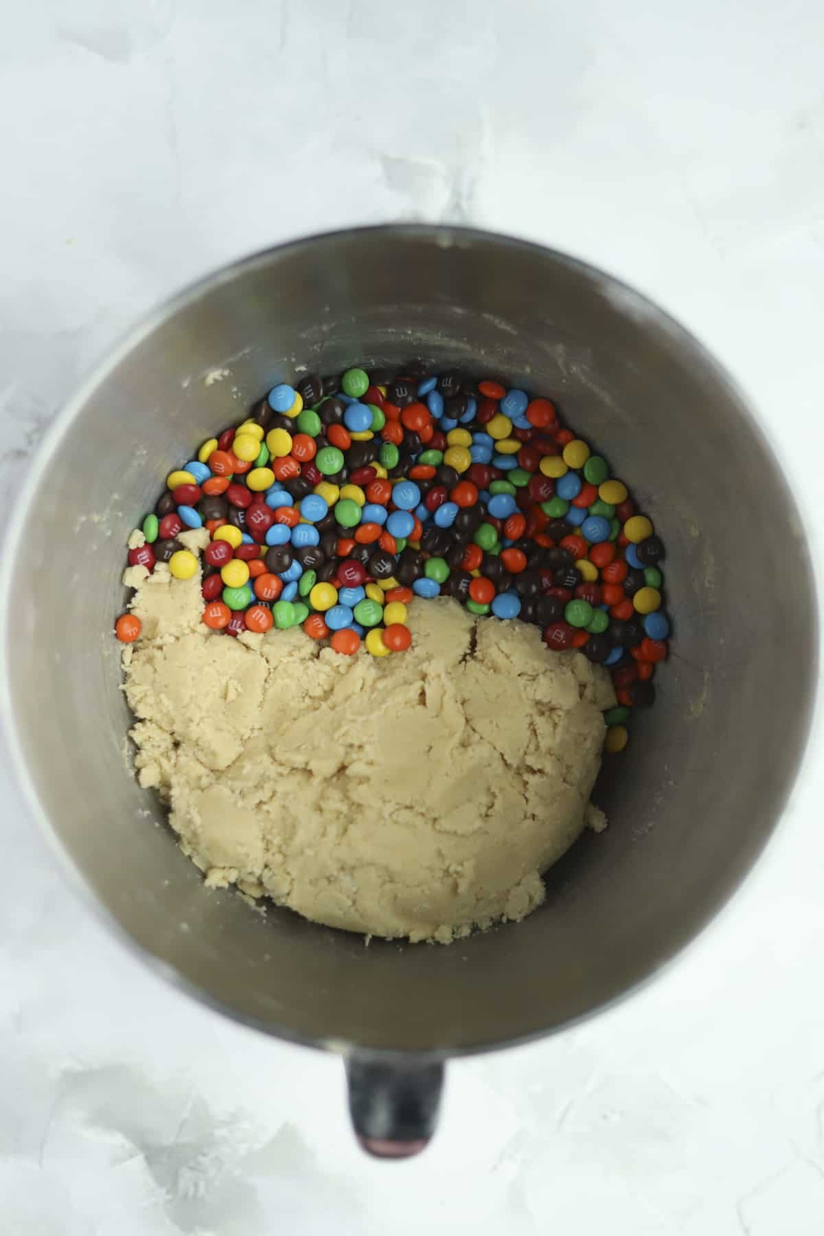 bowl of a stand mixer with cookie dough and m&ms