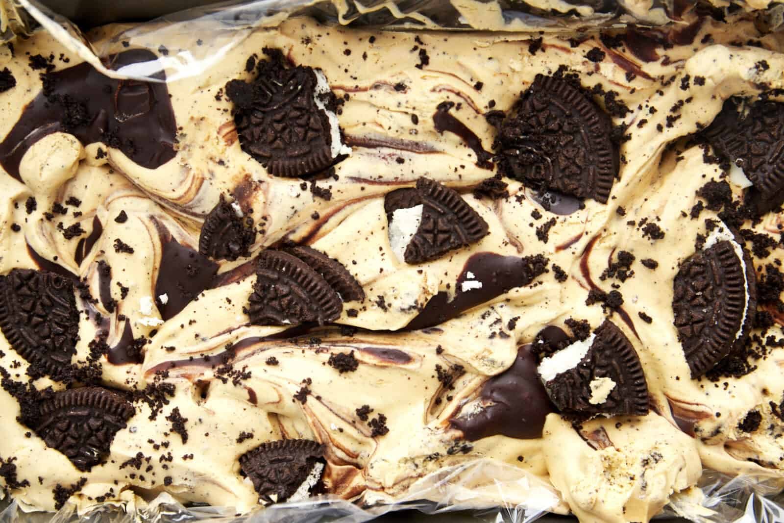 overhead image of mocha Oreo no churn ice cream topped with Oreo chunks in a loaf pan.