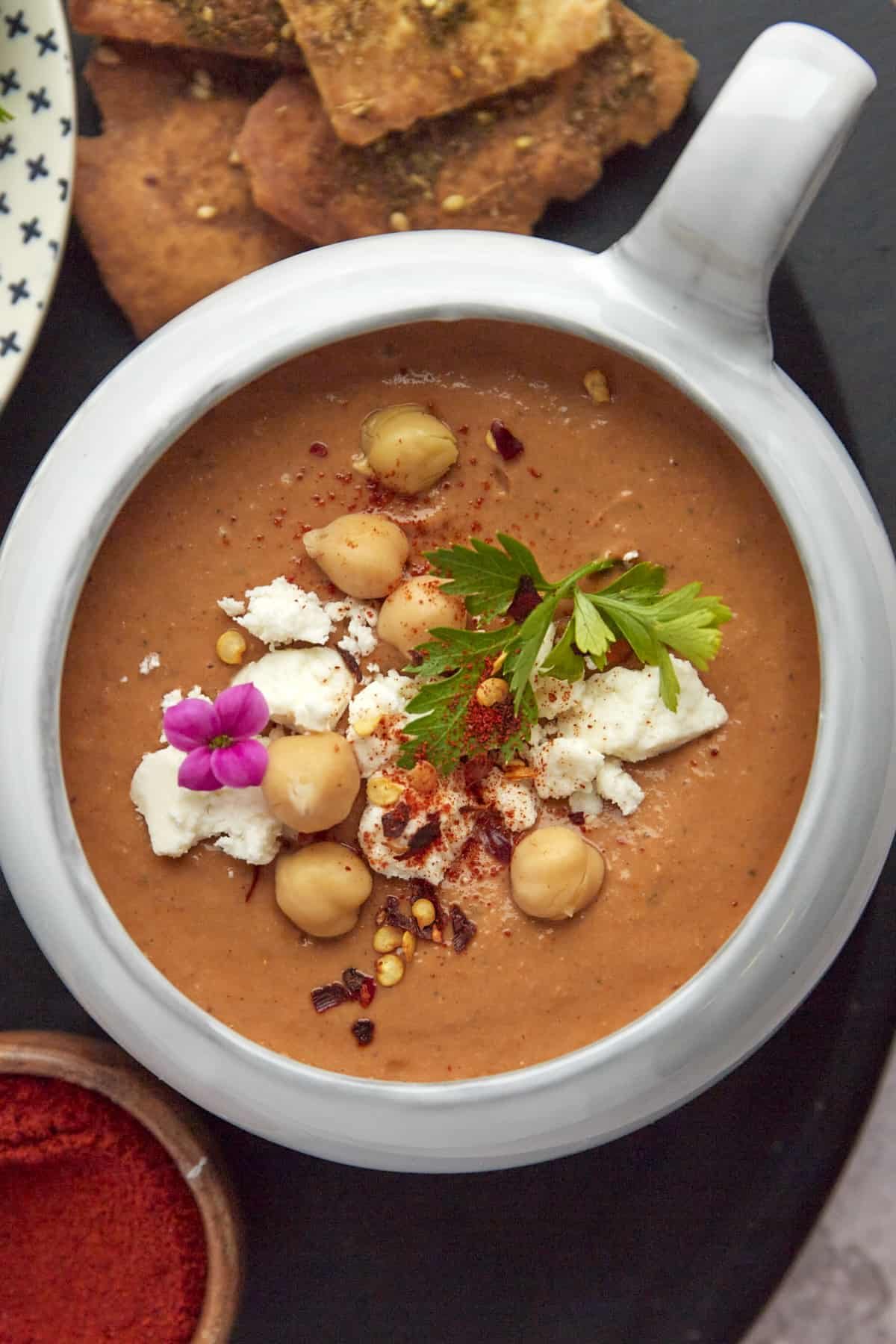 overhead image of a bowl of Moroccan Spicy Tomato Soup with air fryer pita chips on the side