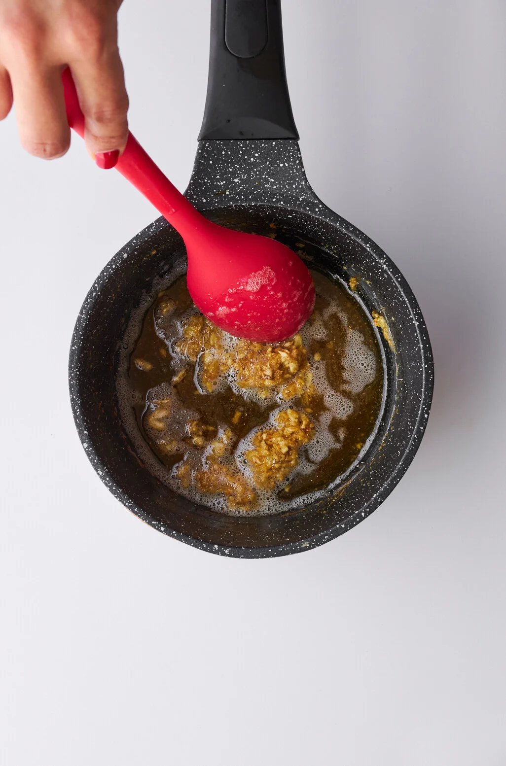 Minced garlic and coriander being sautéed in butter.
