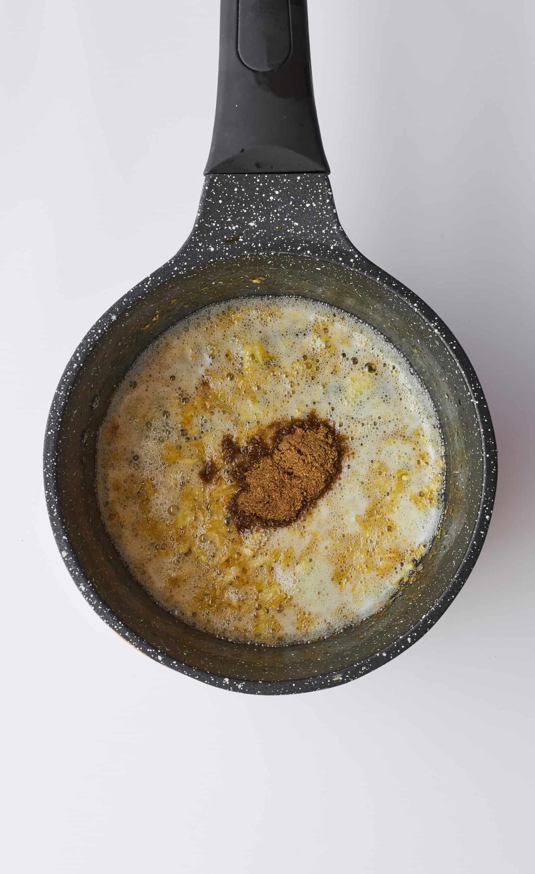 Ground coriander in a pot of minced garlic and butter.