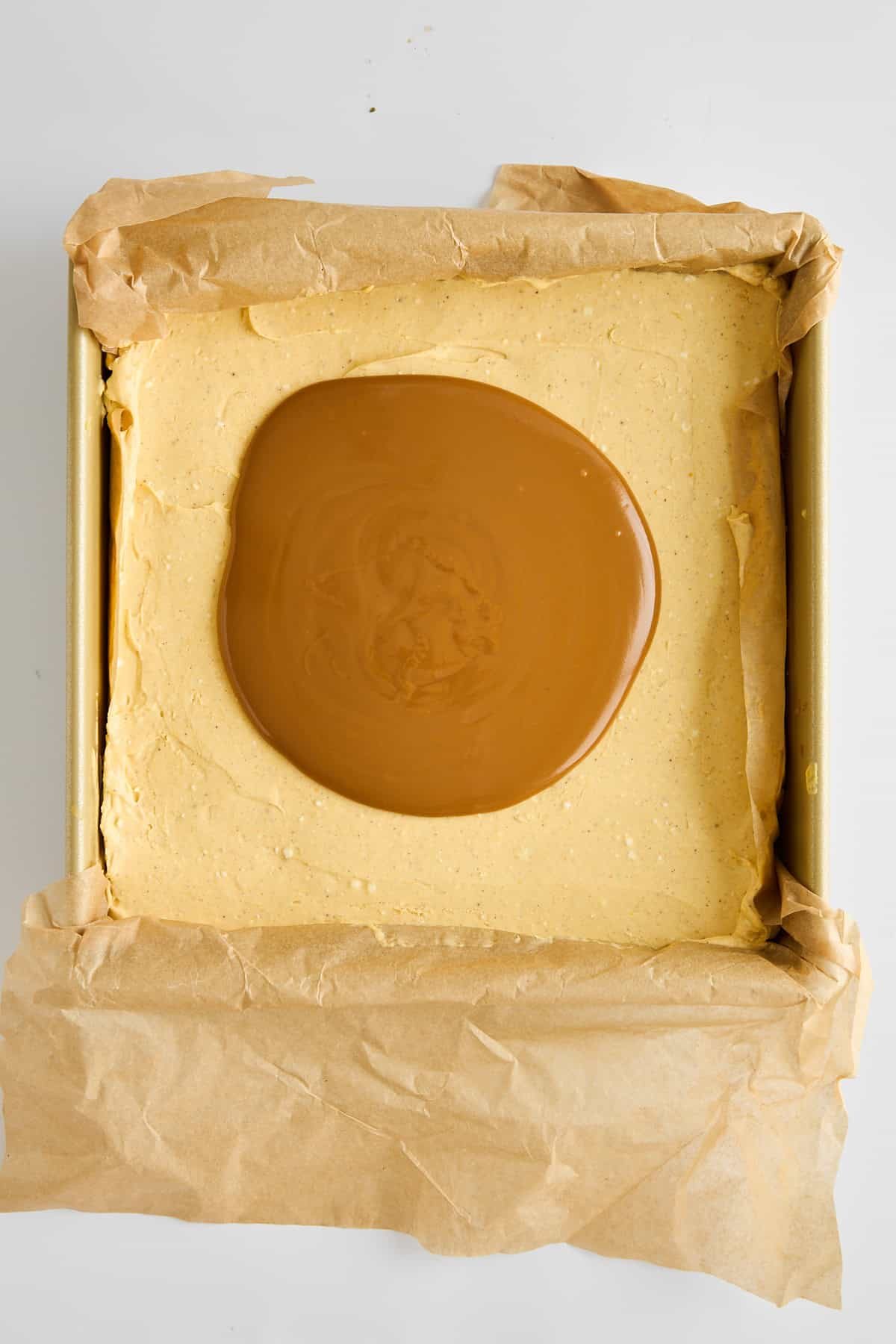 Melted Biscoff butter on top of no-bake pumpkin cheesecake bars.