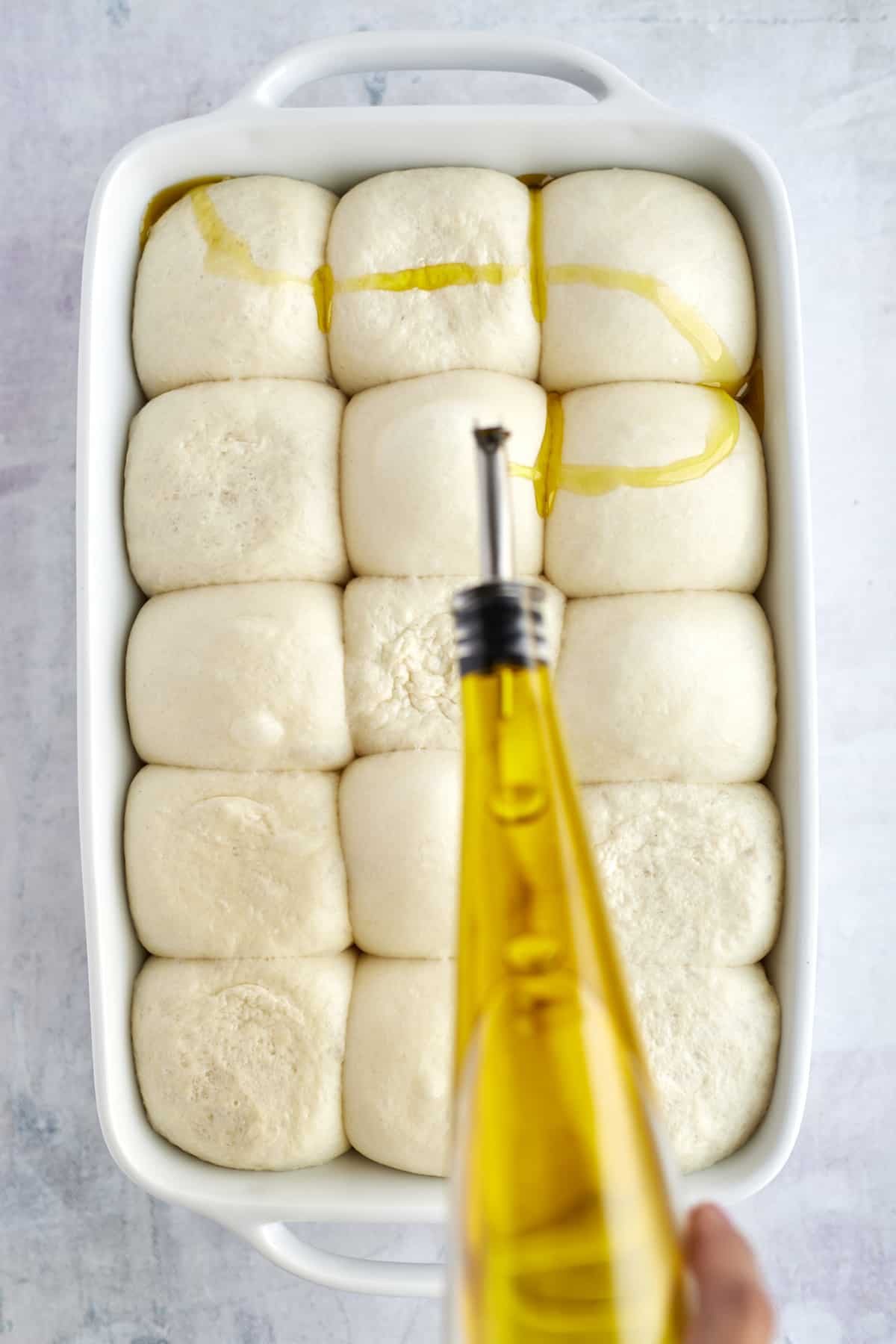 raw rolls with olive oil being drizzled on top