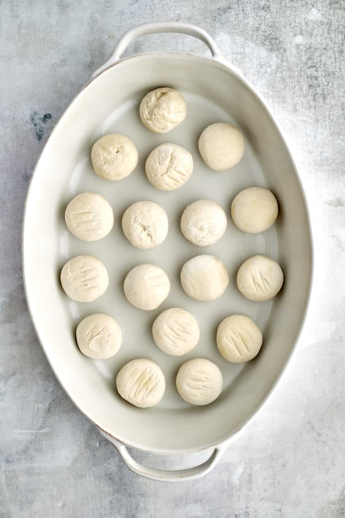 raw bread roll dough in a baking dish
