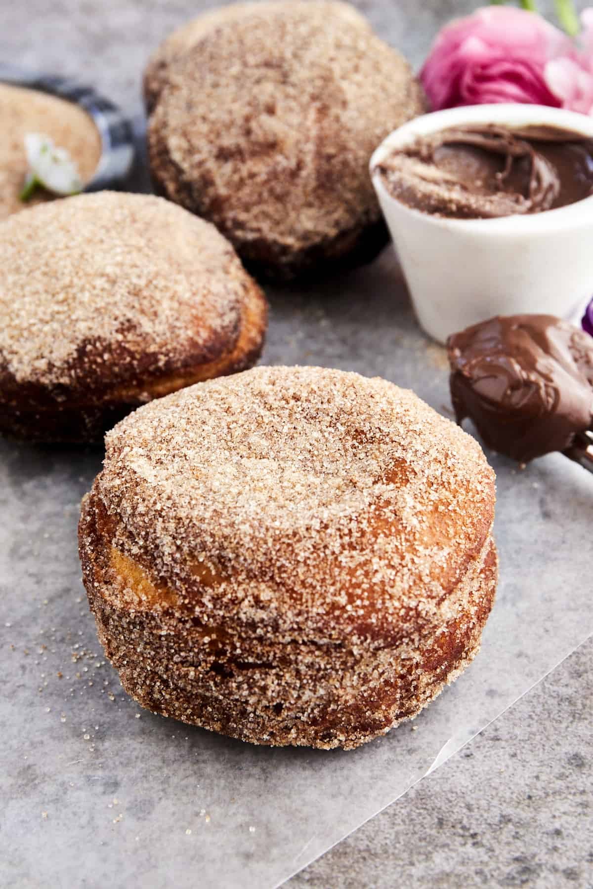 Close up image of Nutella stuffed biscuit doughnuts coated in cinnamon sugar.