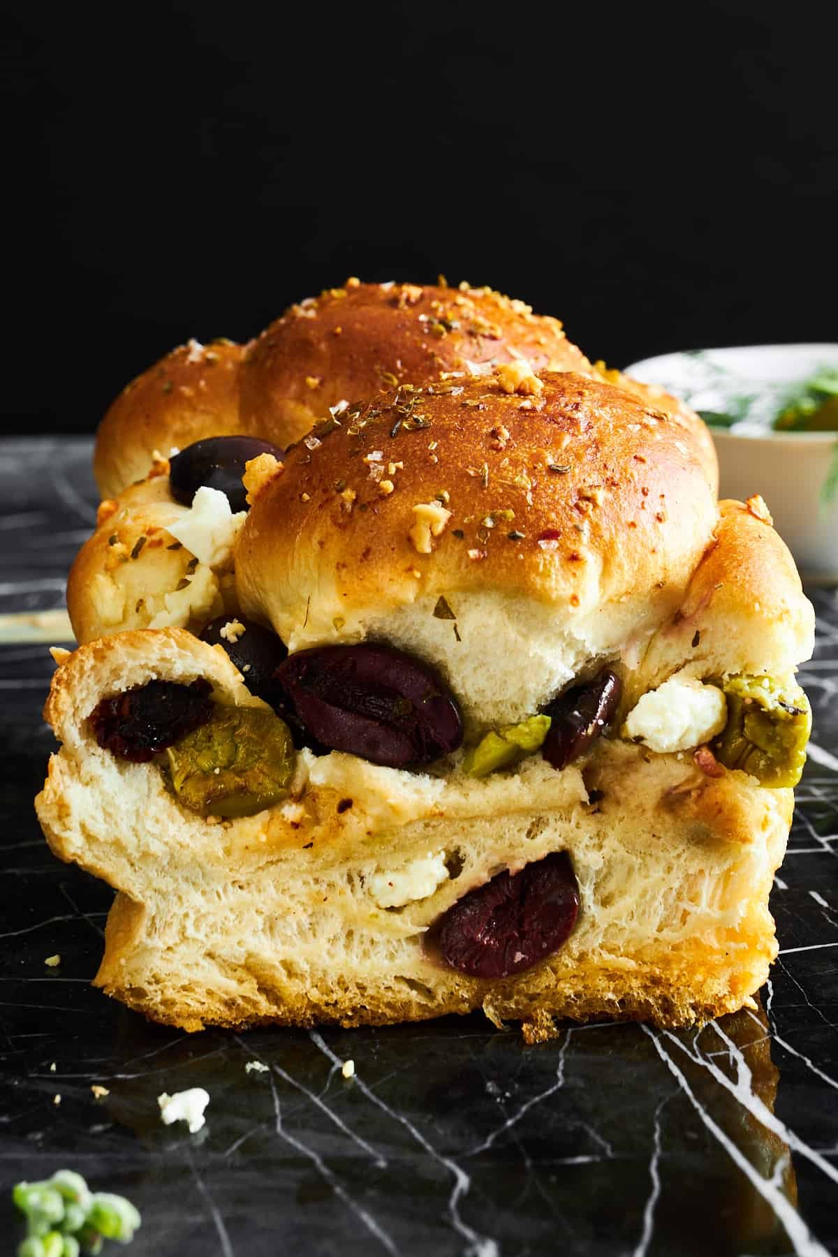 Side view of a loaf of olive bread with feta.