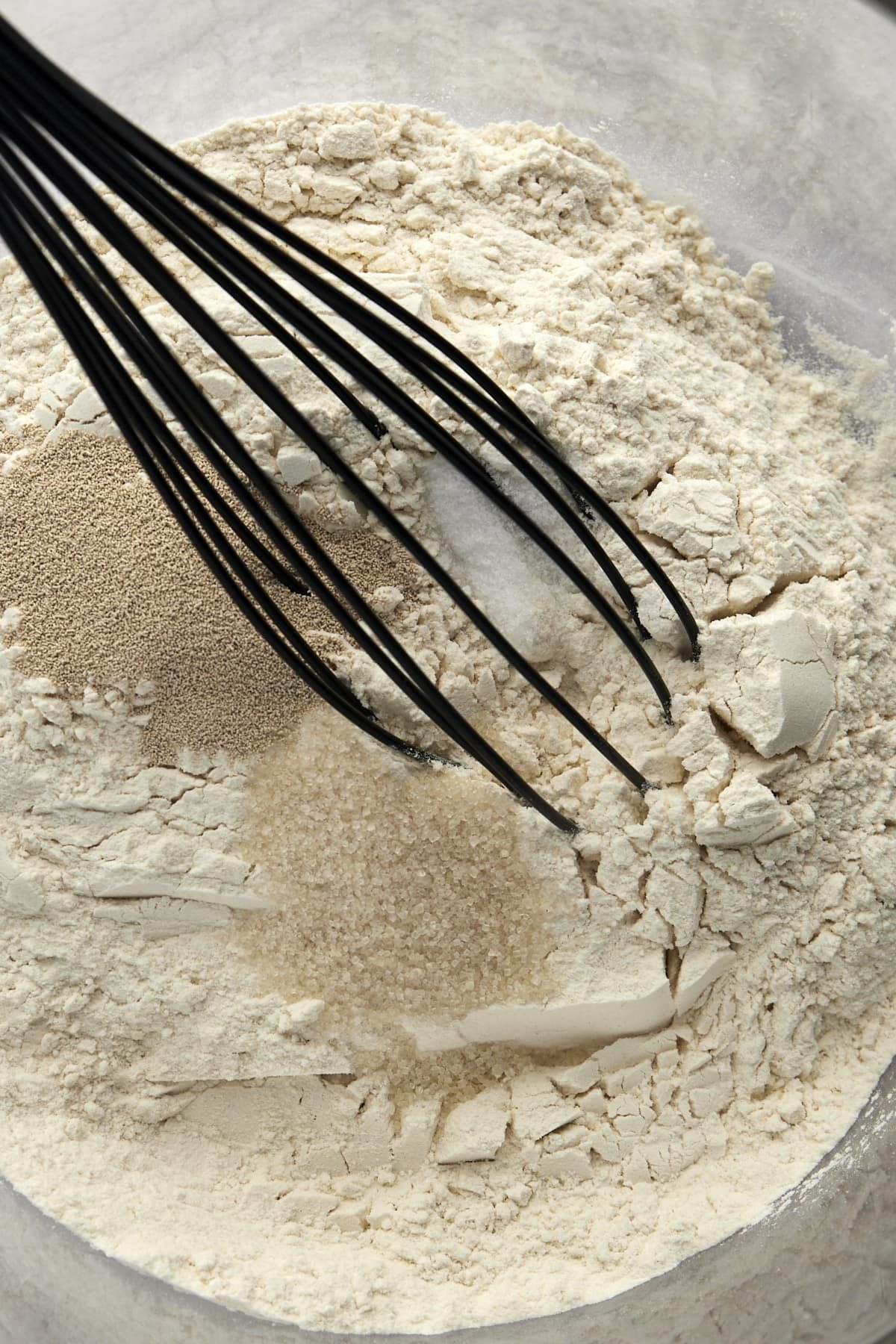 Flour, salt, and yeast being mixed.
