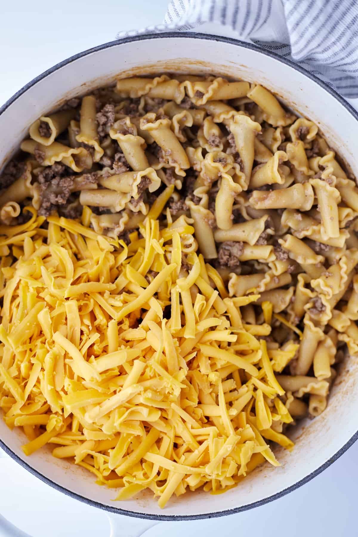 cooked one pot hamburger pasta topped with shredded cheese.