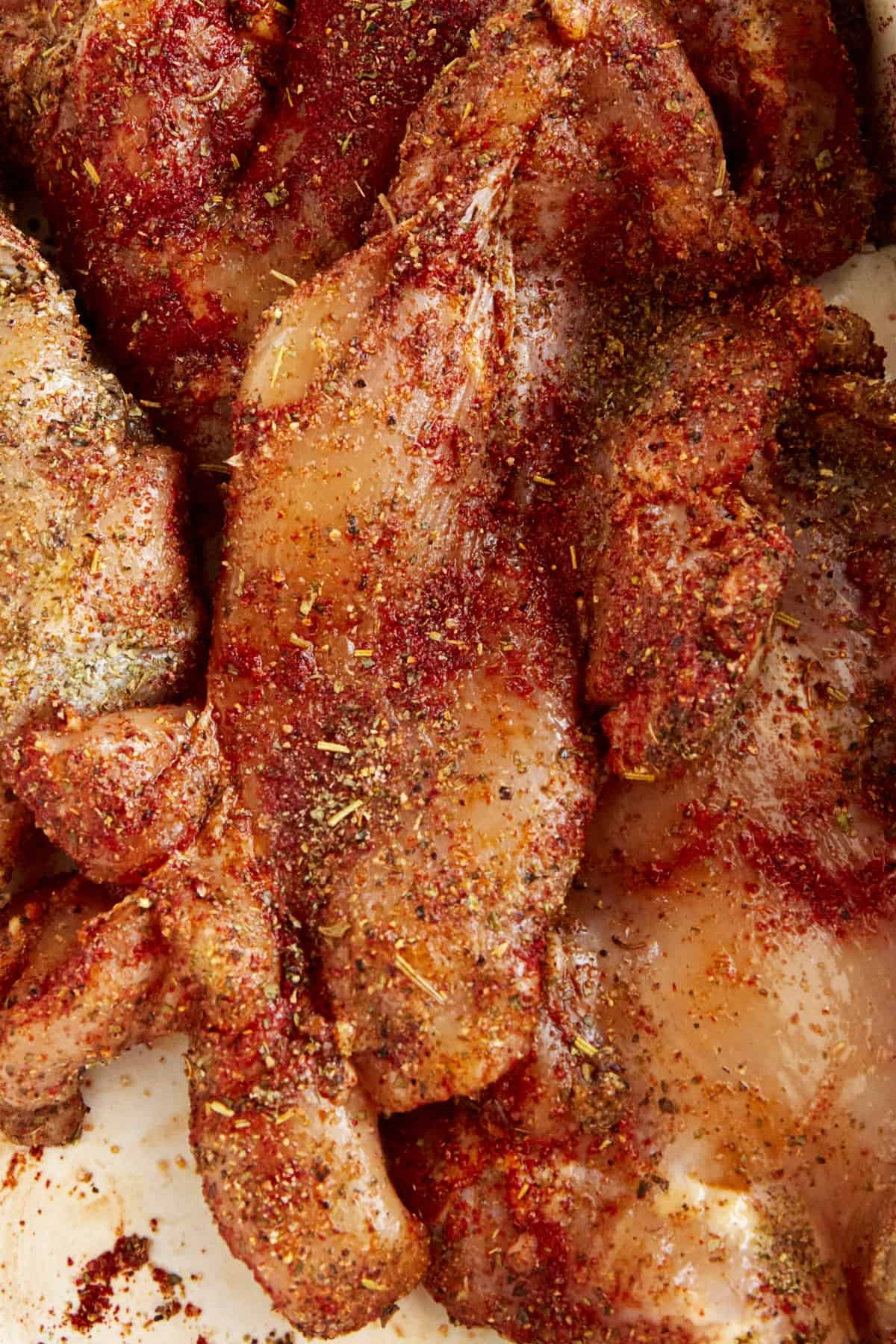Raw seasoned chicken breast pieces.