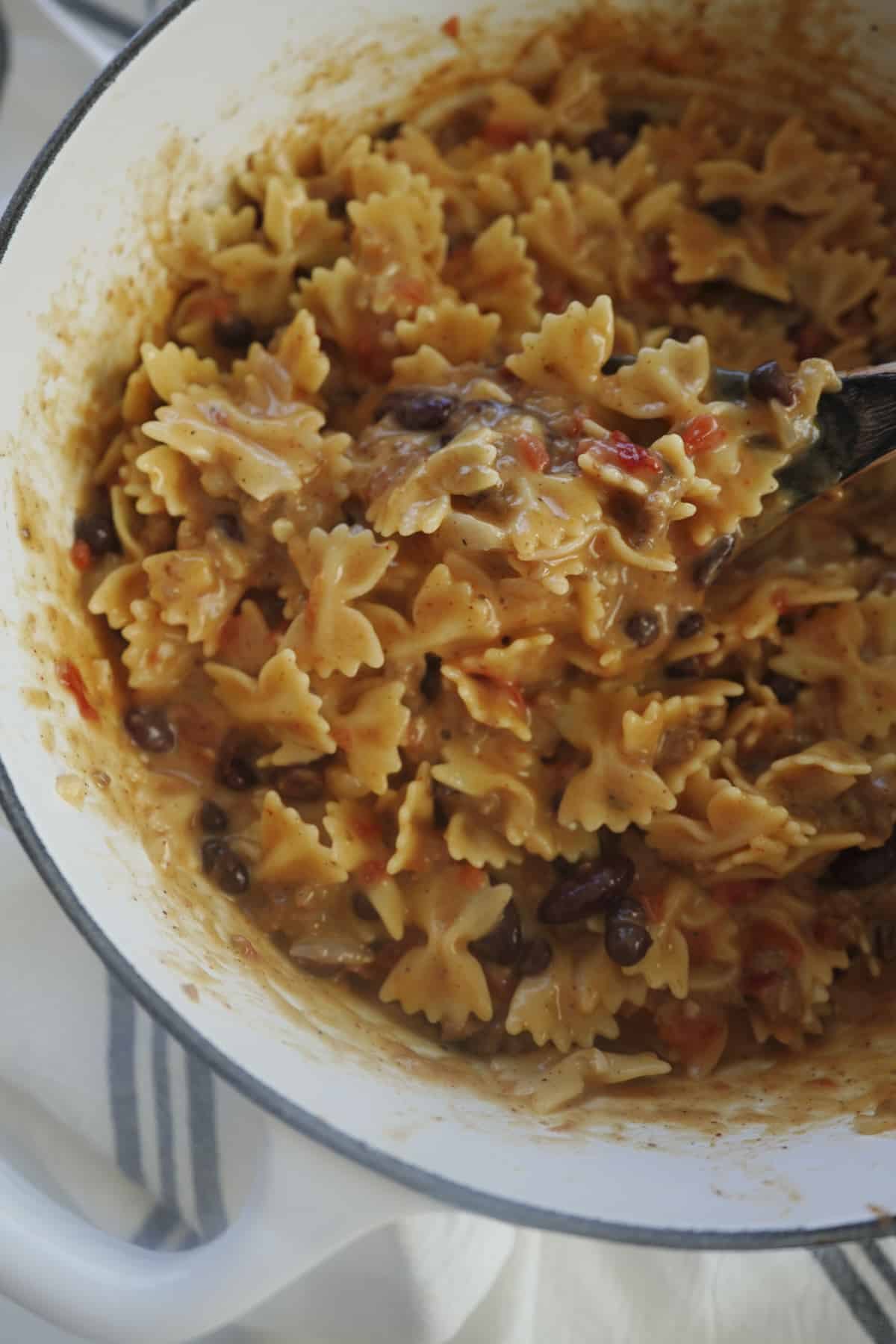 a spoon stirring one pot chili mac and cheese