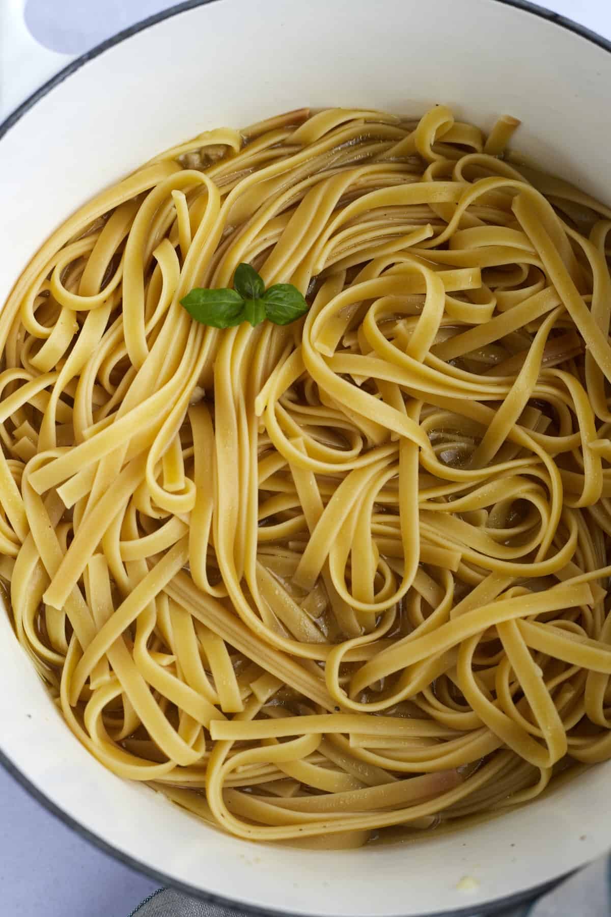 Cooked fettuccine noodles in a pot.