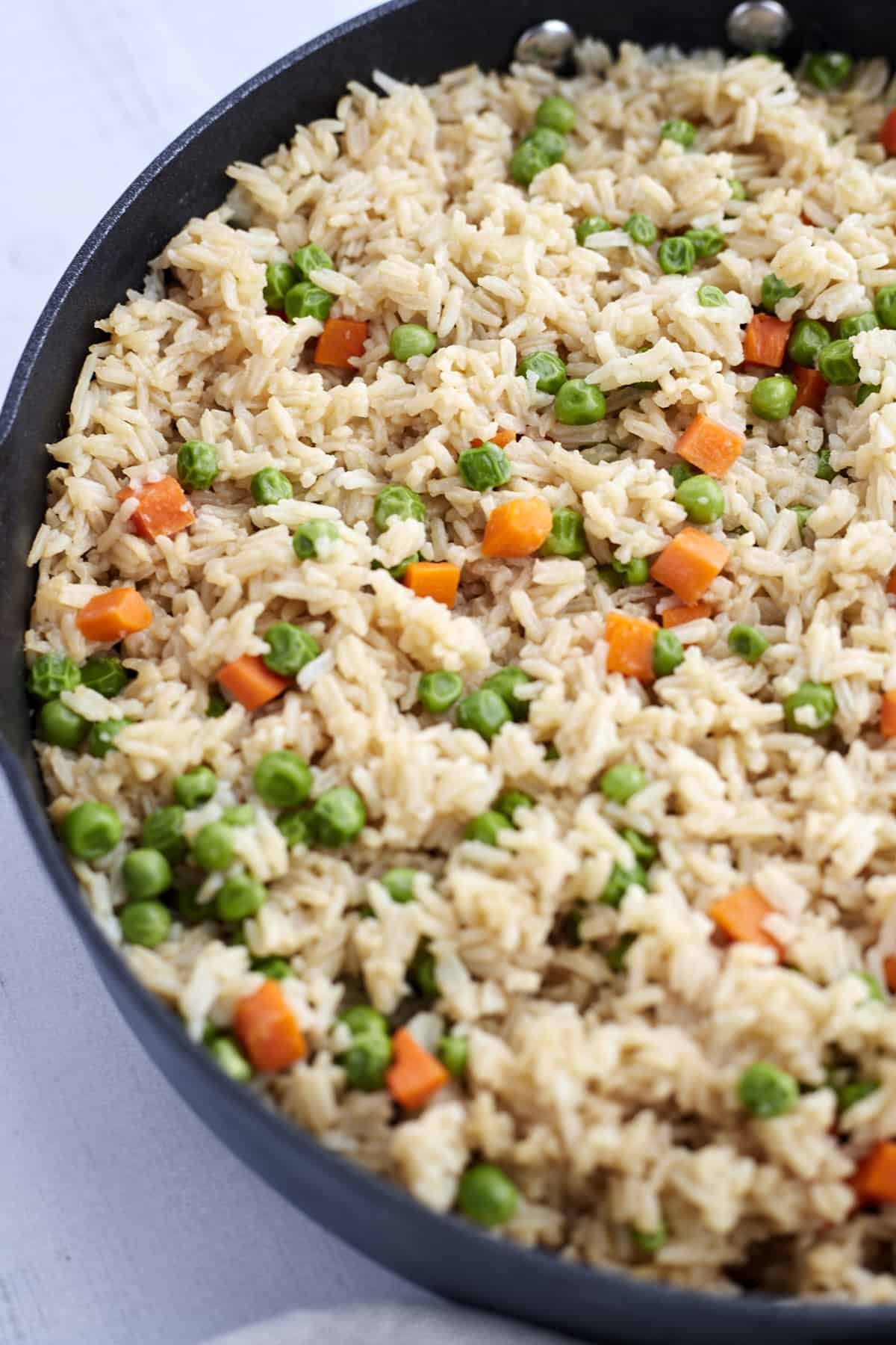 A skillet with rice and veggies.
