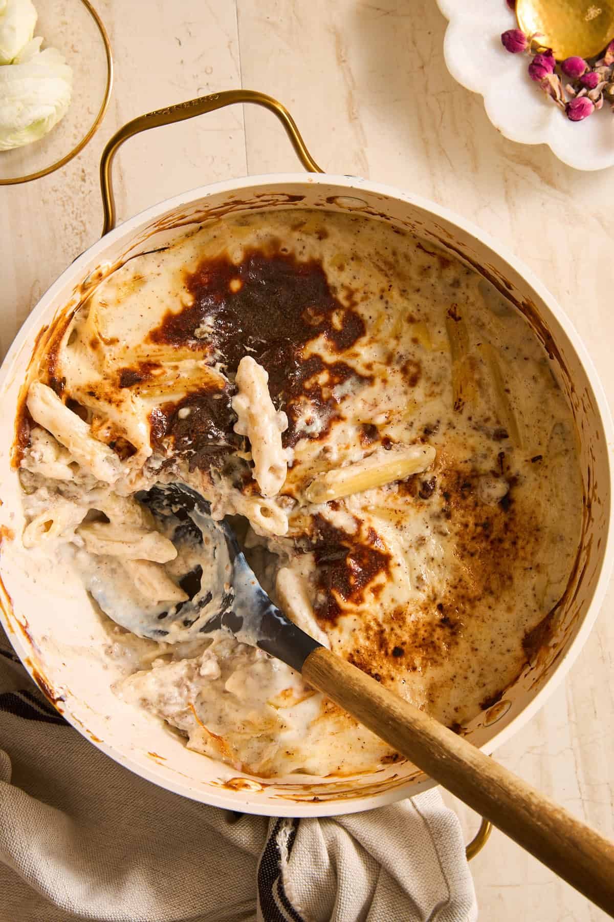 A spoon scooping macarona Bechamel out of a pot.