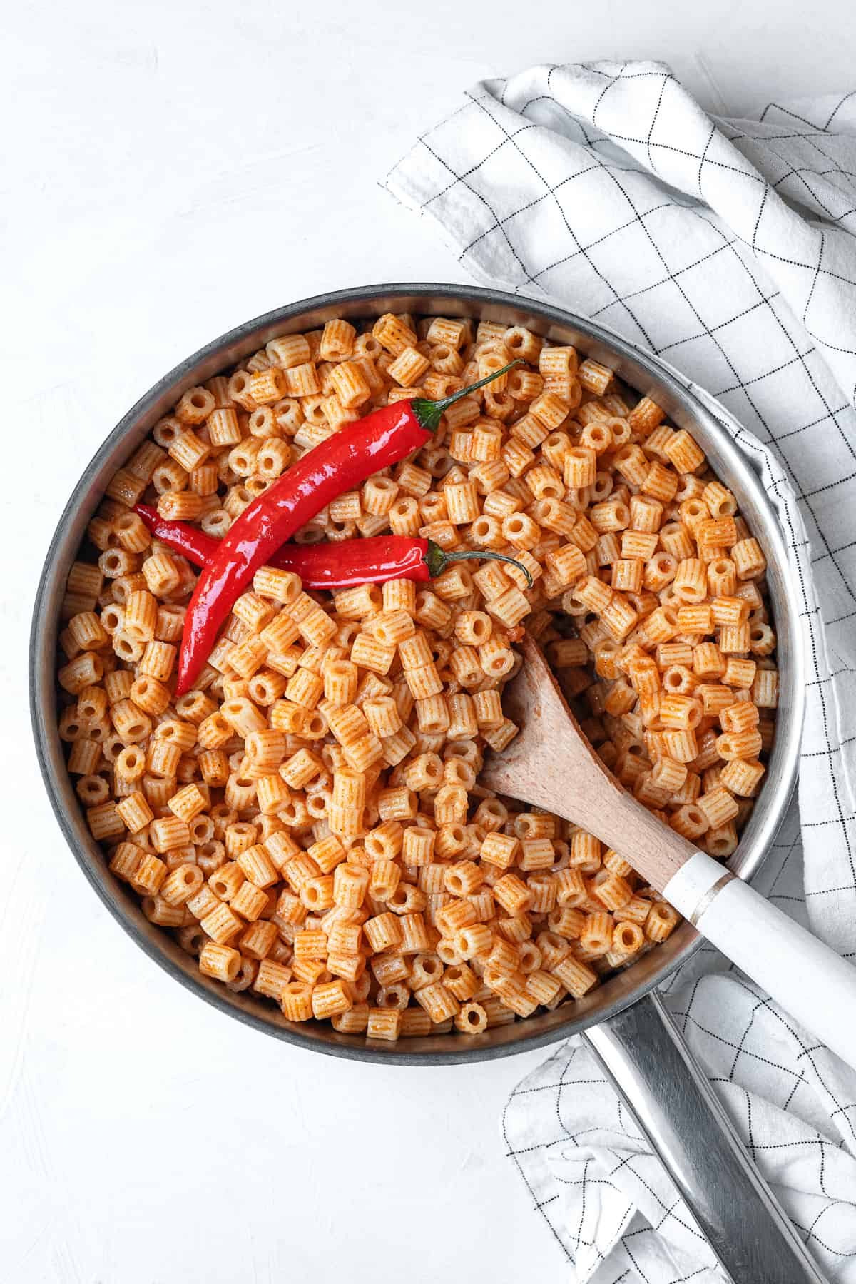one pot mbakbaka topped with peppers with a spoon sticking out