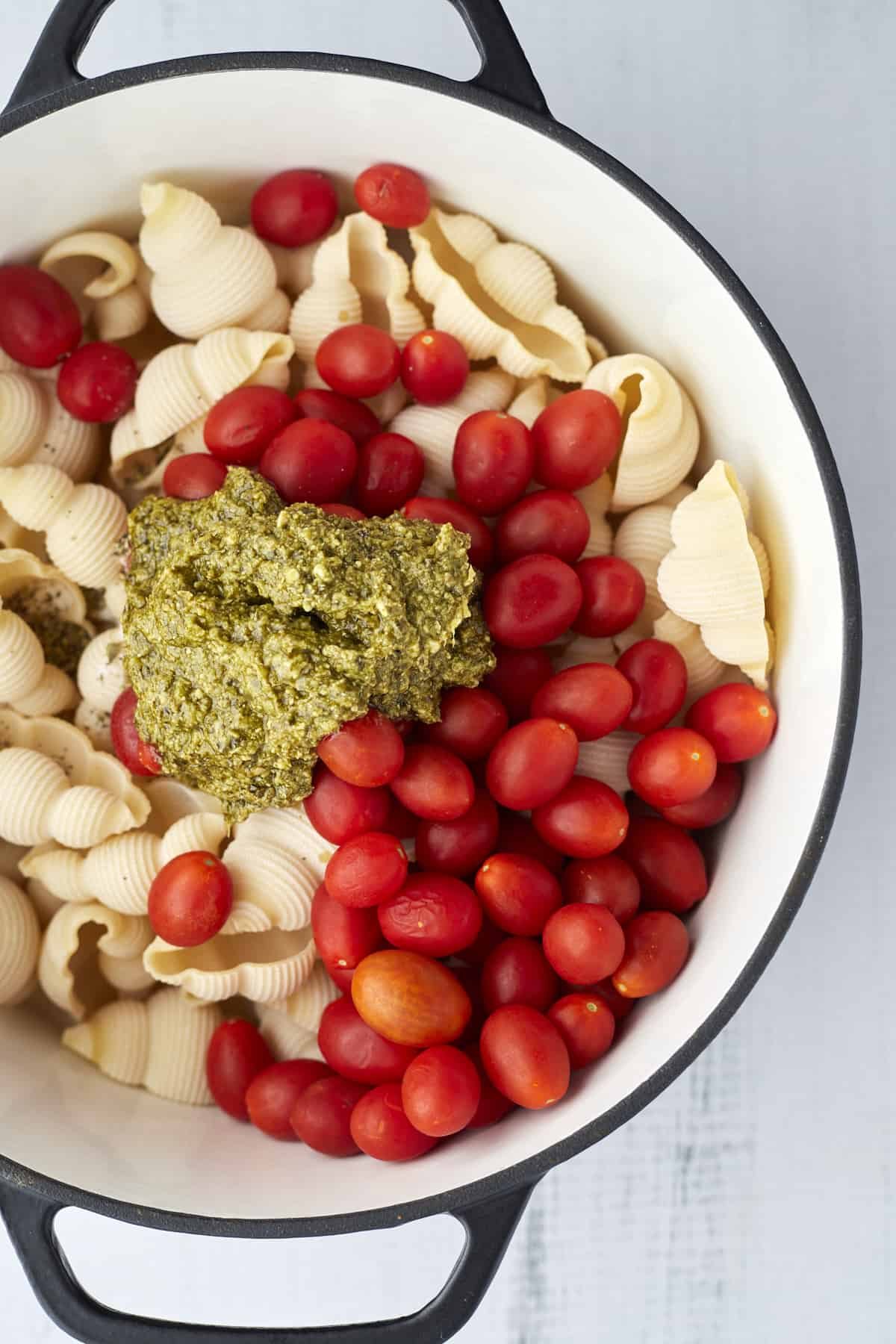 pasta shells, tomatoes, and pesto in a large pot