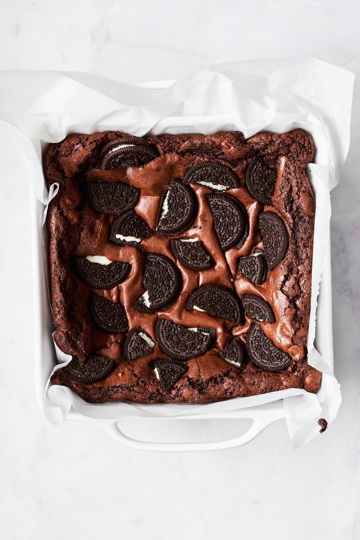 A baking dish full of brownies with Oreos on top.