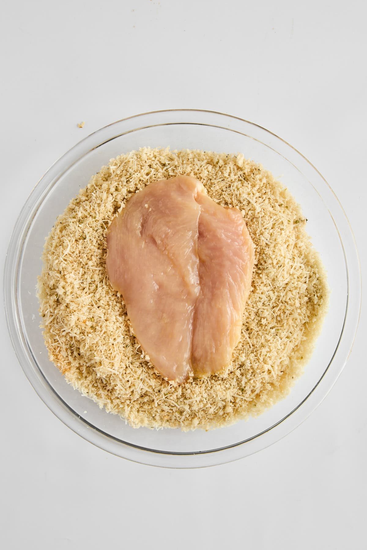 Raw chicken being breaded.