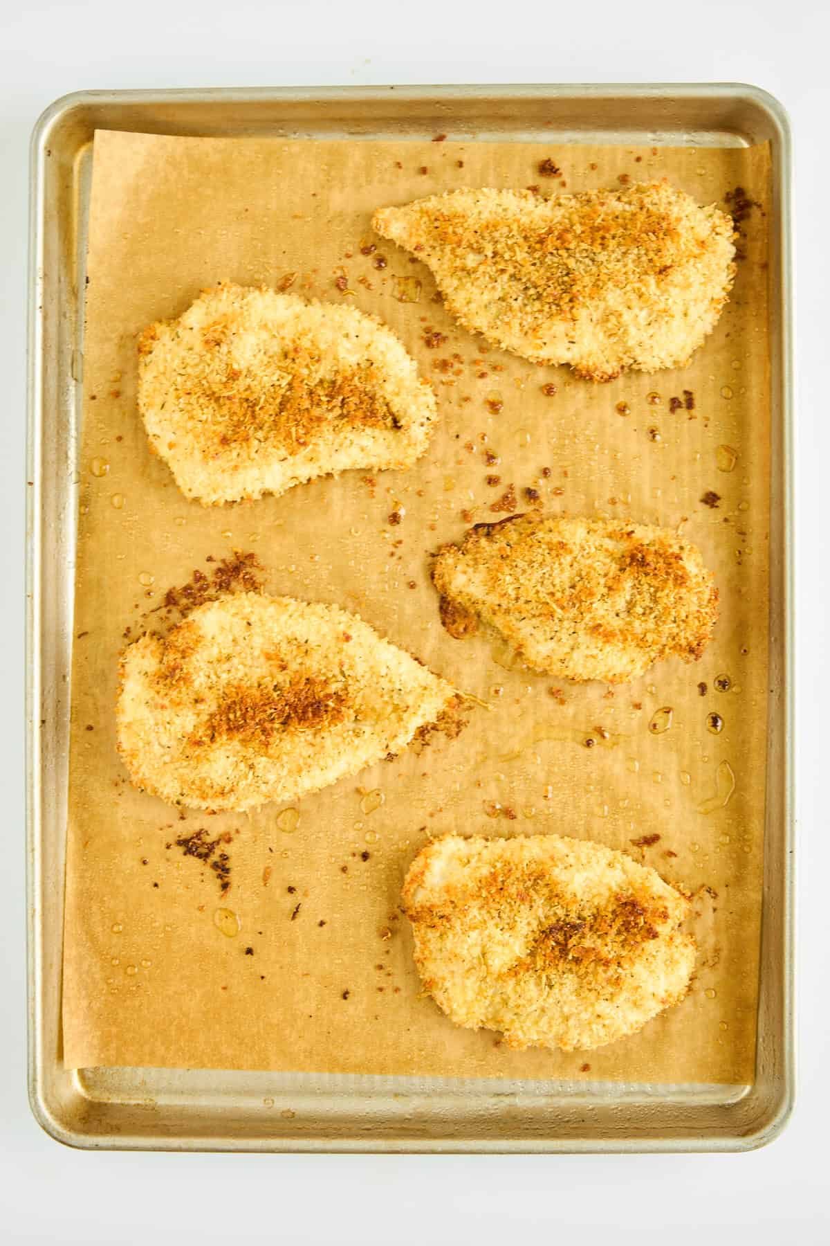 Easy Oven Fried Chicken pieces on a baking sheet.