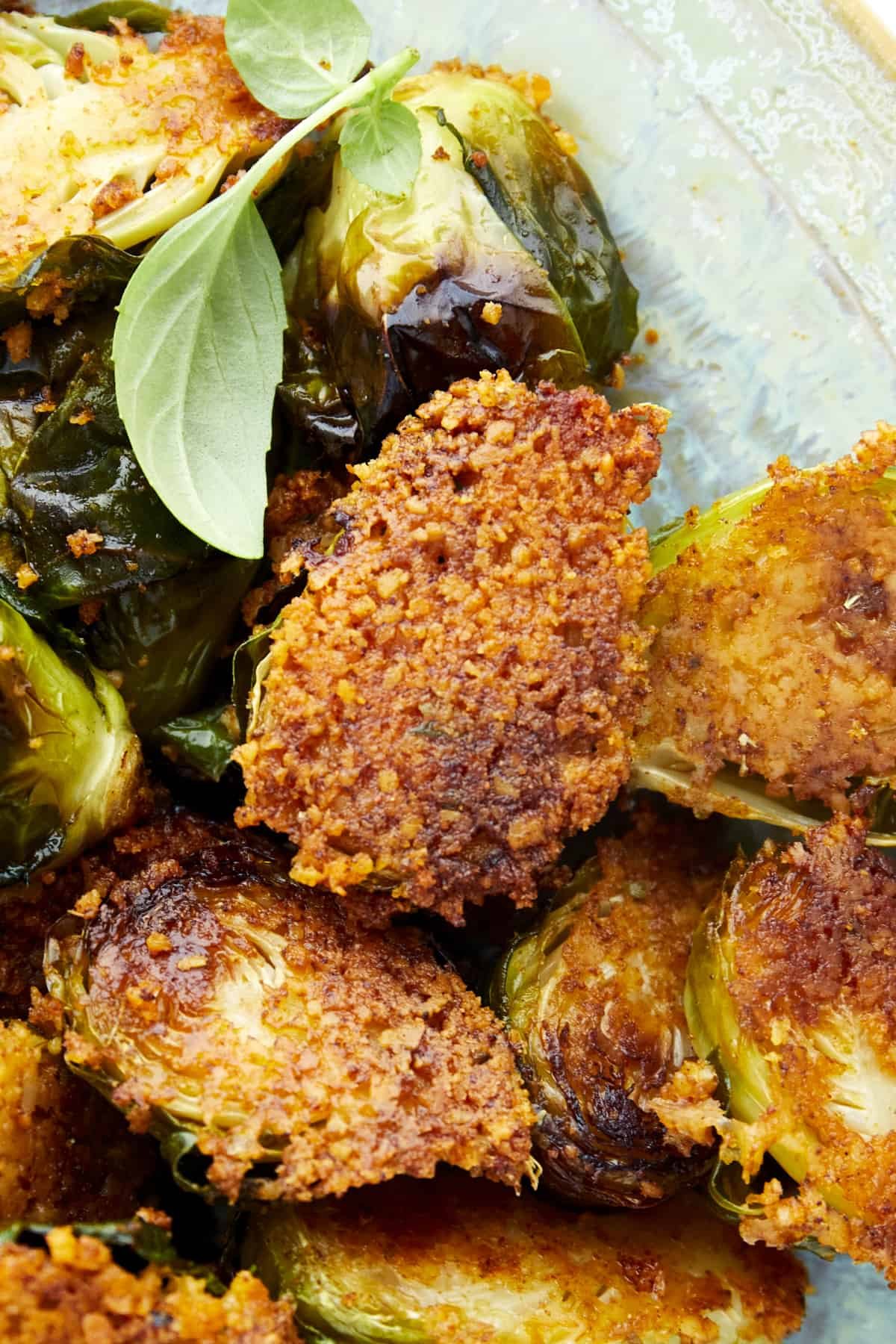 Close up image of a Brussels sprout coated with Parmesan.