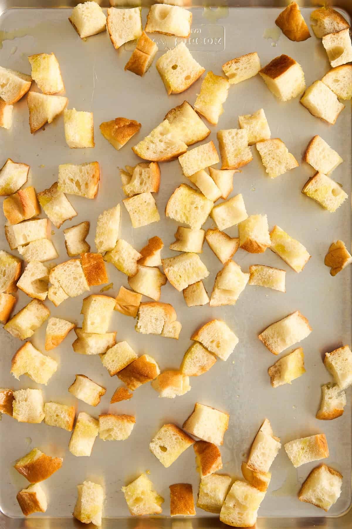 Bread pieces on a baking sheet.