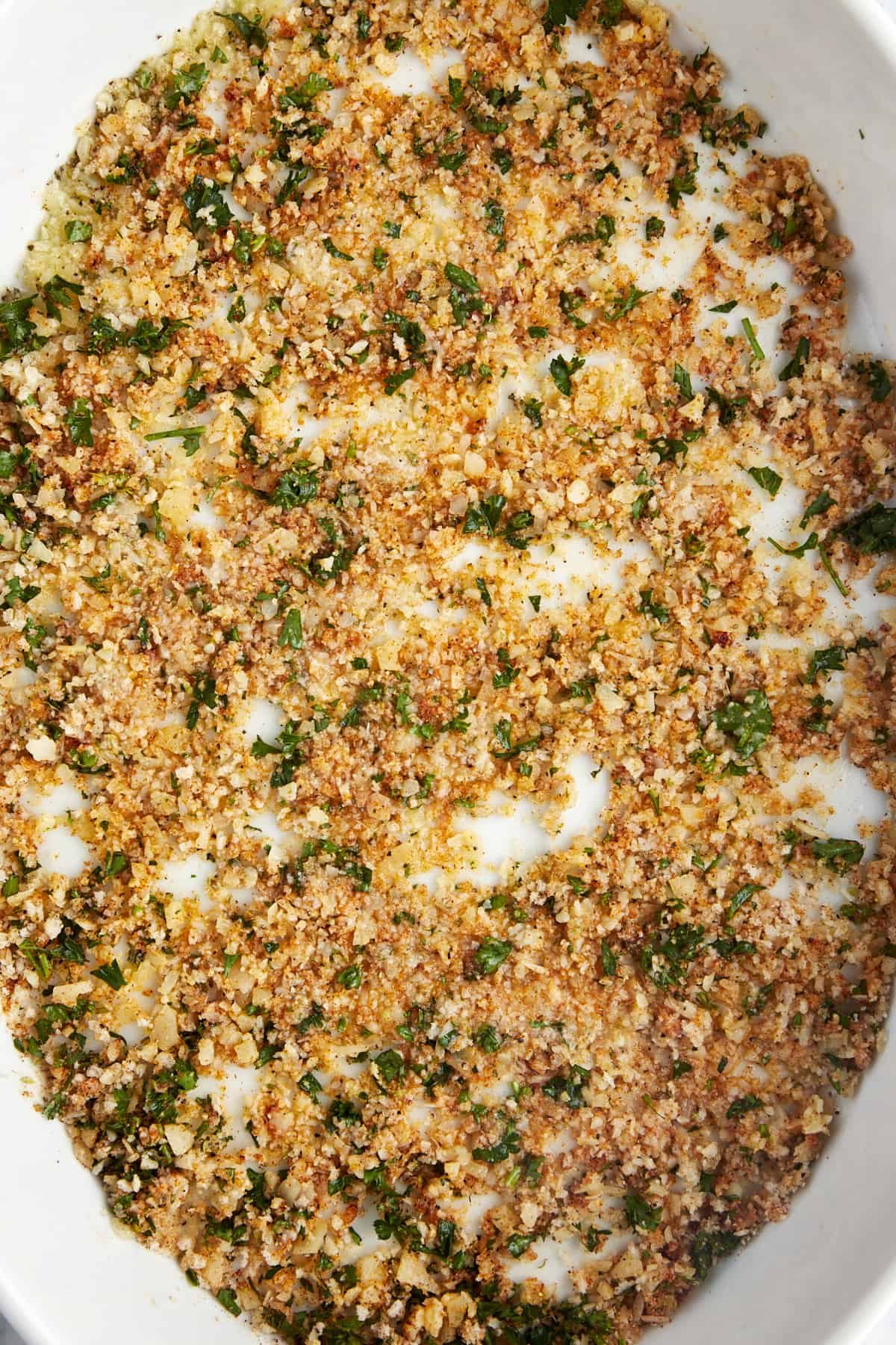 Breadcrumbs, butter, herbs, and spices in a 9x13 baking dish.