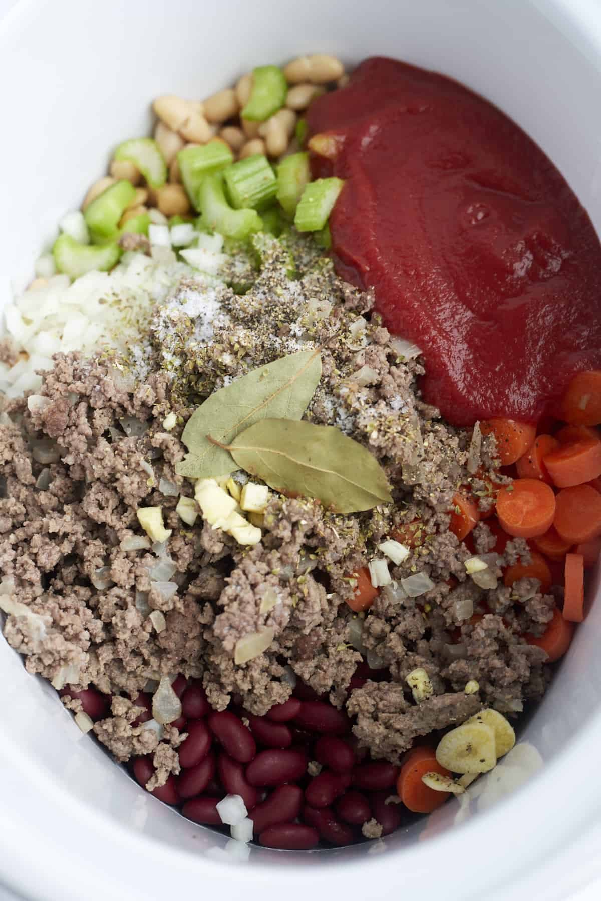 beef, veggies, beans, tomato sauce, and seasoning in a slow cooker.