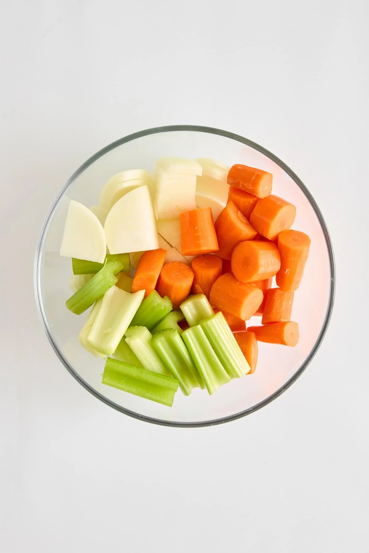 Carrots, celery, and onion in a bowl.