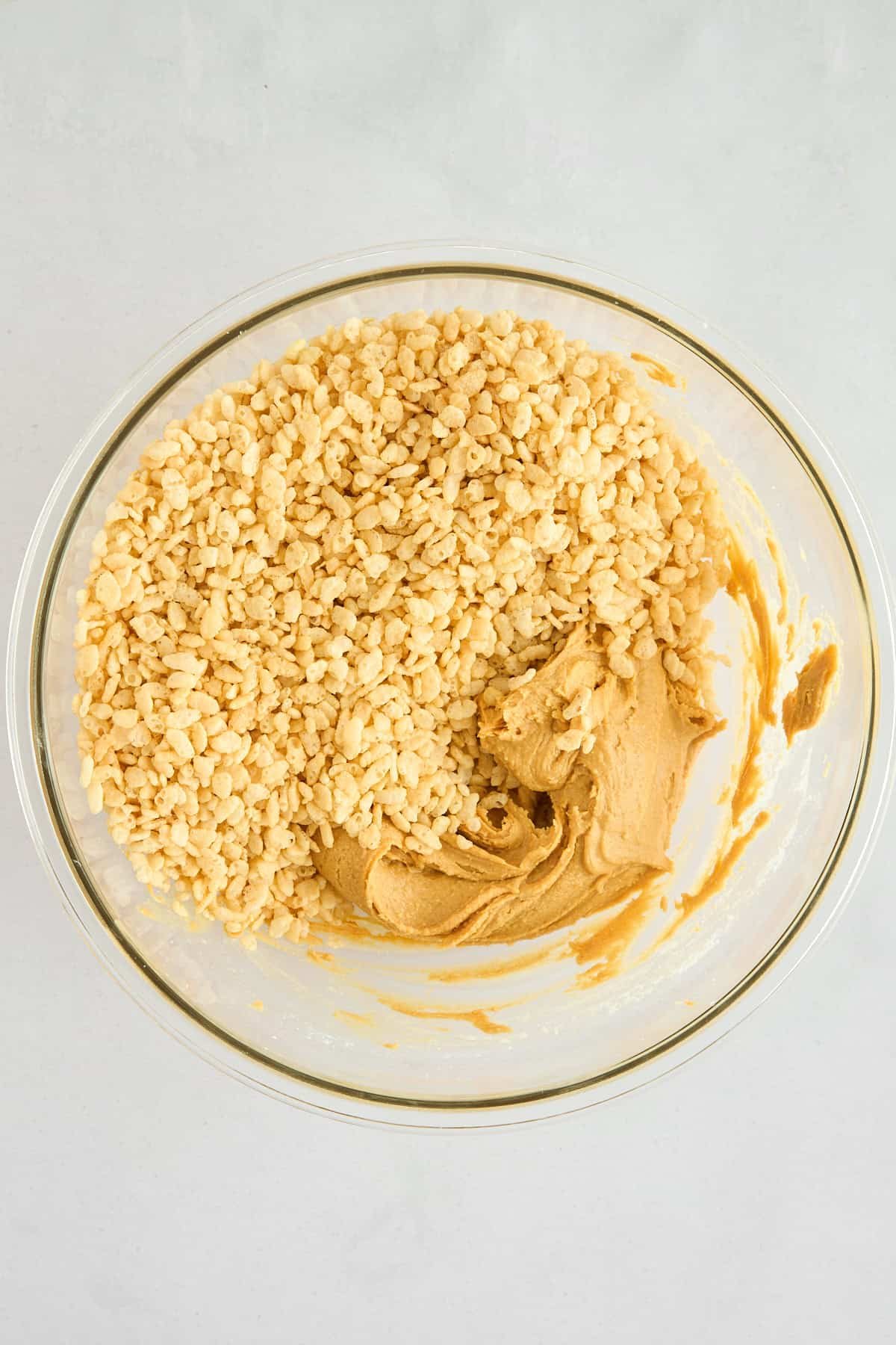 Rice Krispies being stirred into a peanut butter mixture.