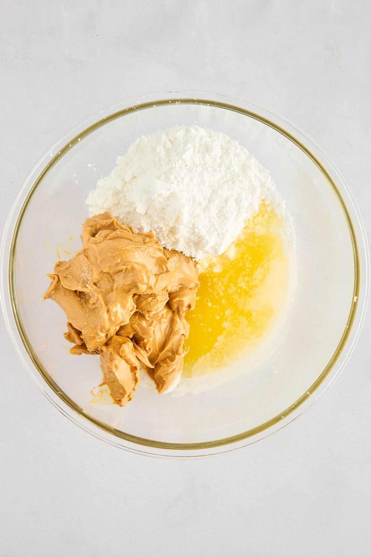 Peanut butter, powdered sugar, and melted butter in a bowl.