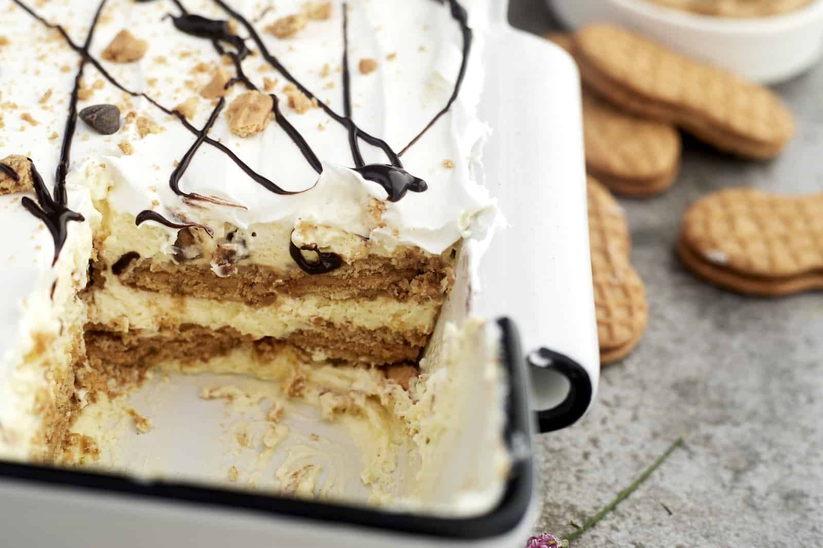 a pan of no-bake peanut butter lasagna with a slice missing from the corner