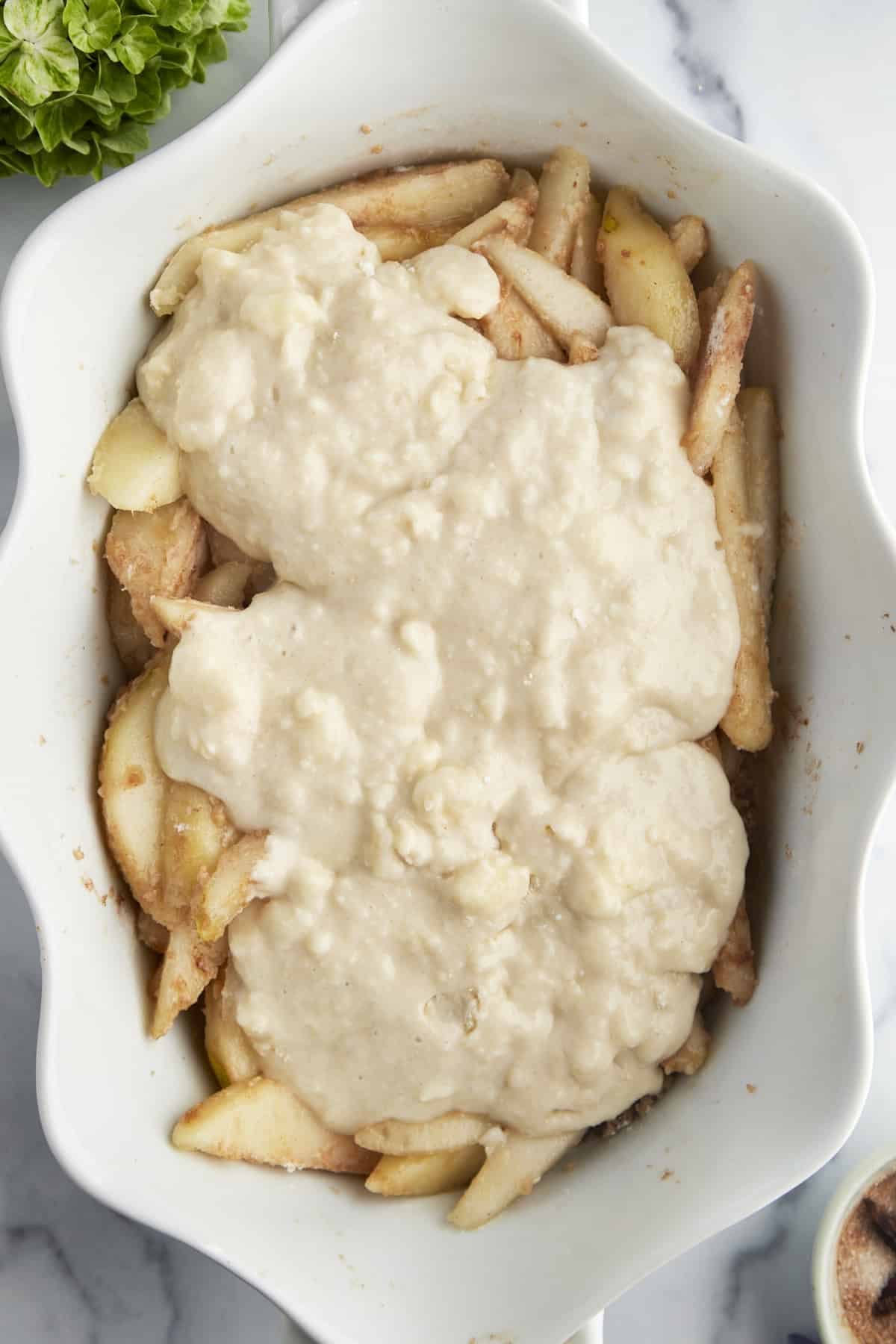 Unbaked pear cobbler in a baking dish.