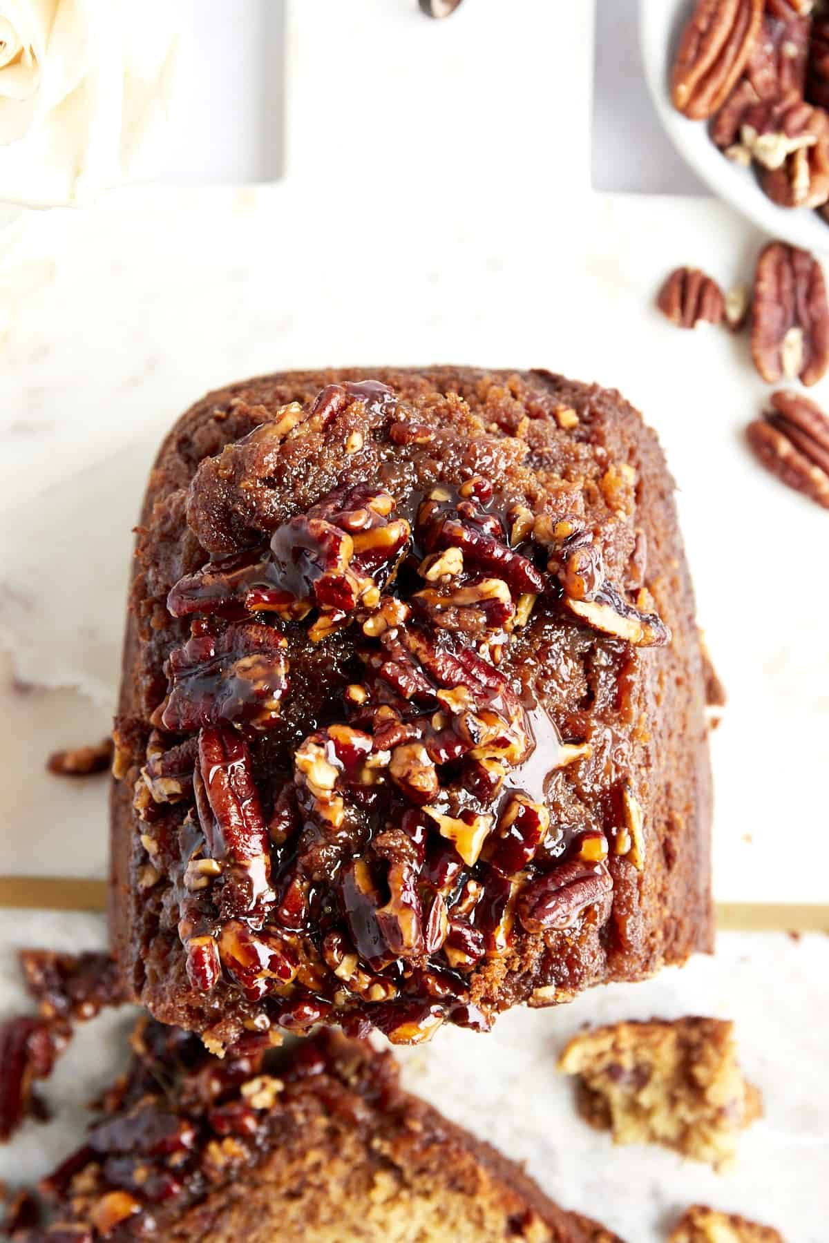 Overhead view of a loaf of banana pecan bread with slices missing.
