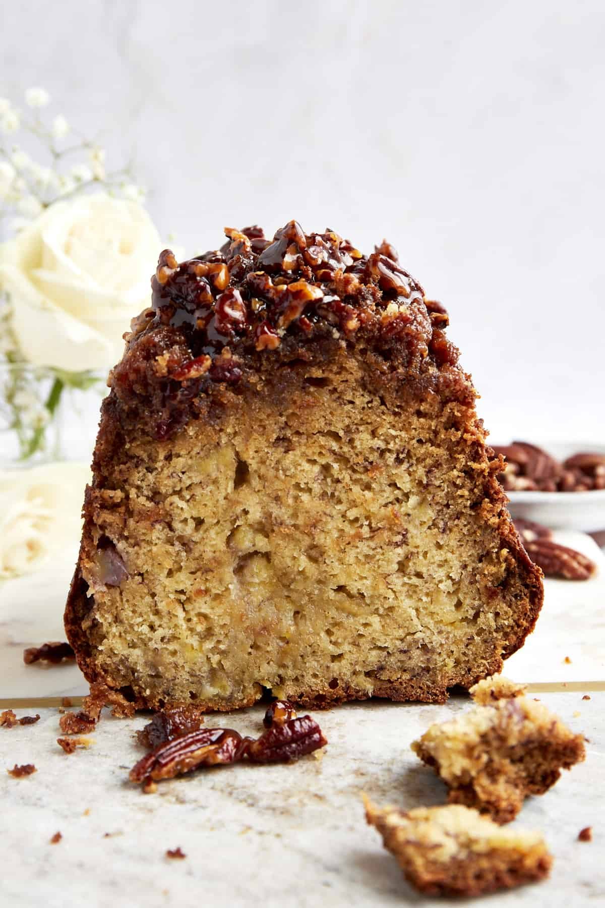 Side view of simple banana pecan bread with a sticky pecan topping.
