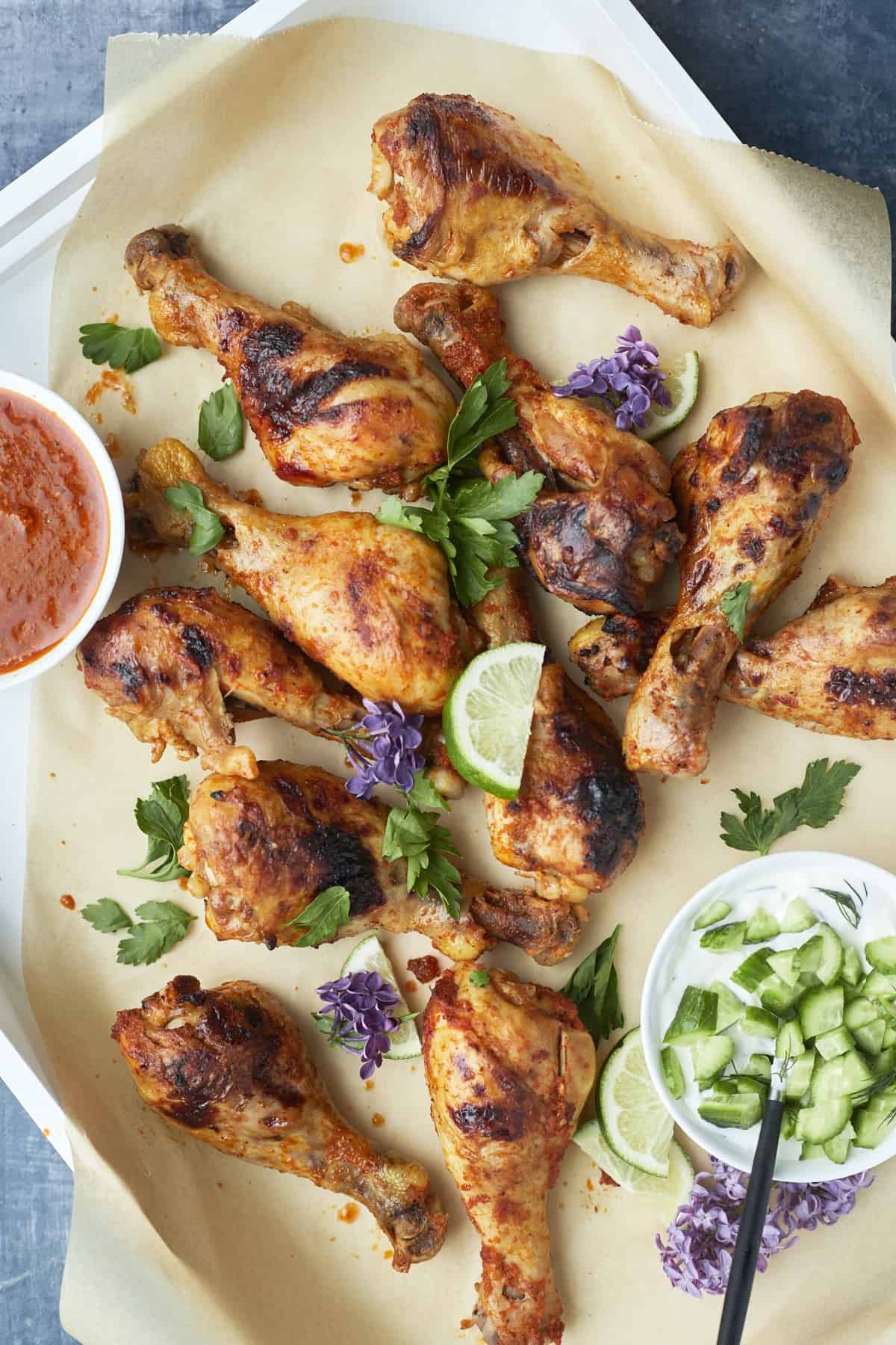 baked peri peri chicken drumsticks in a baking dish on top of parchment paper