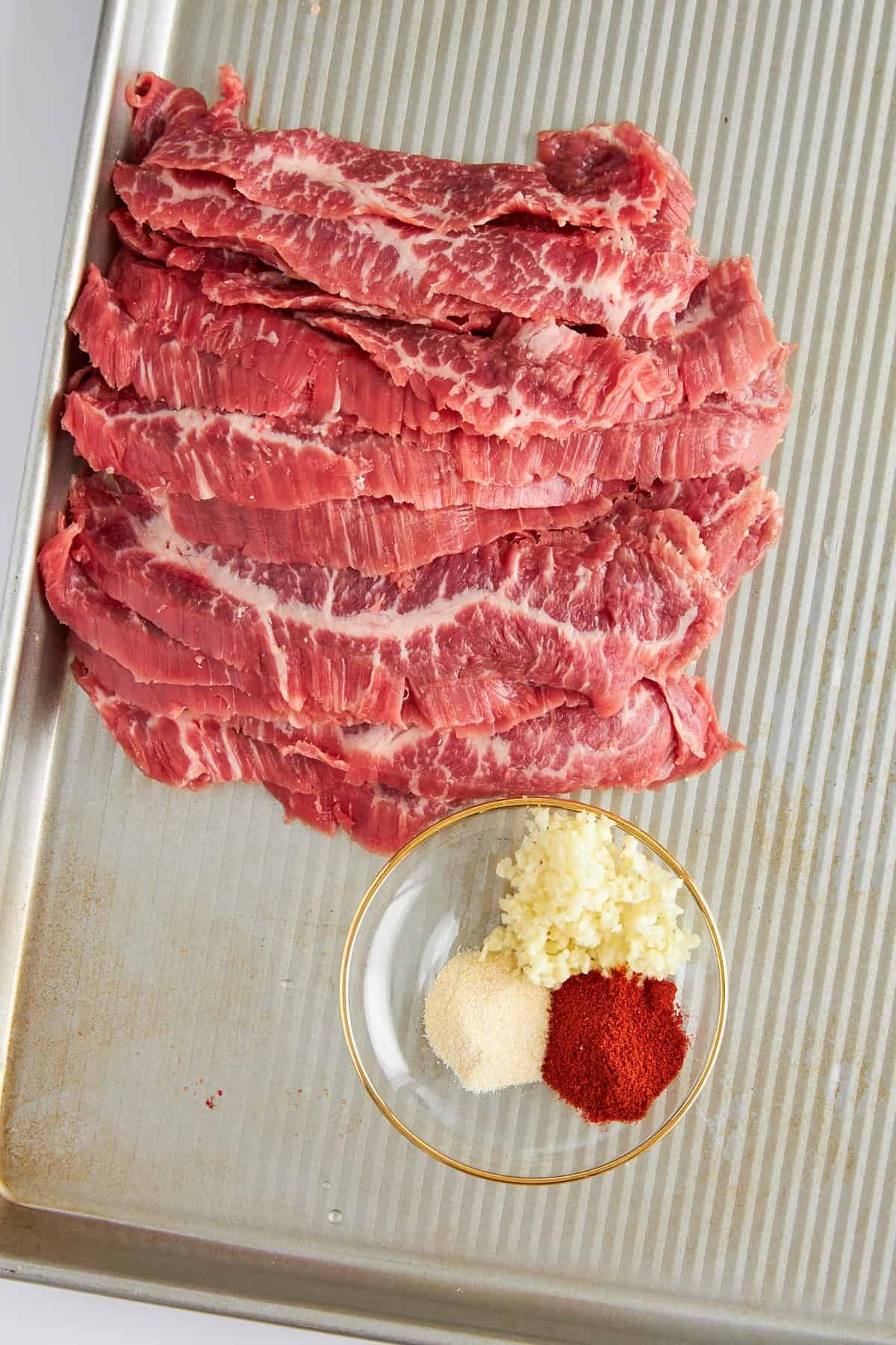 Steak strips on a baking sheet.