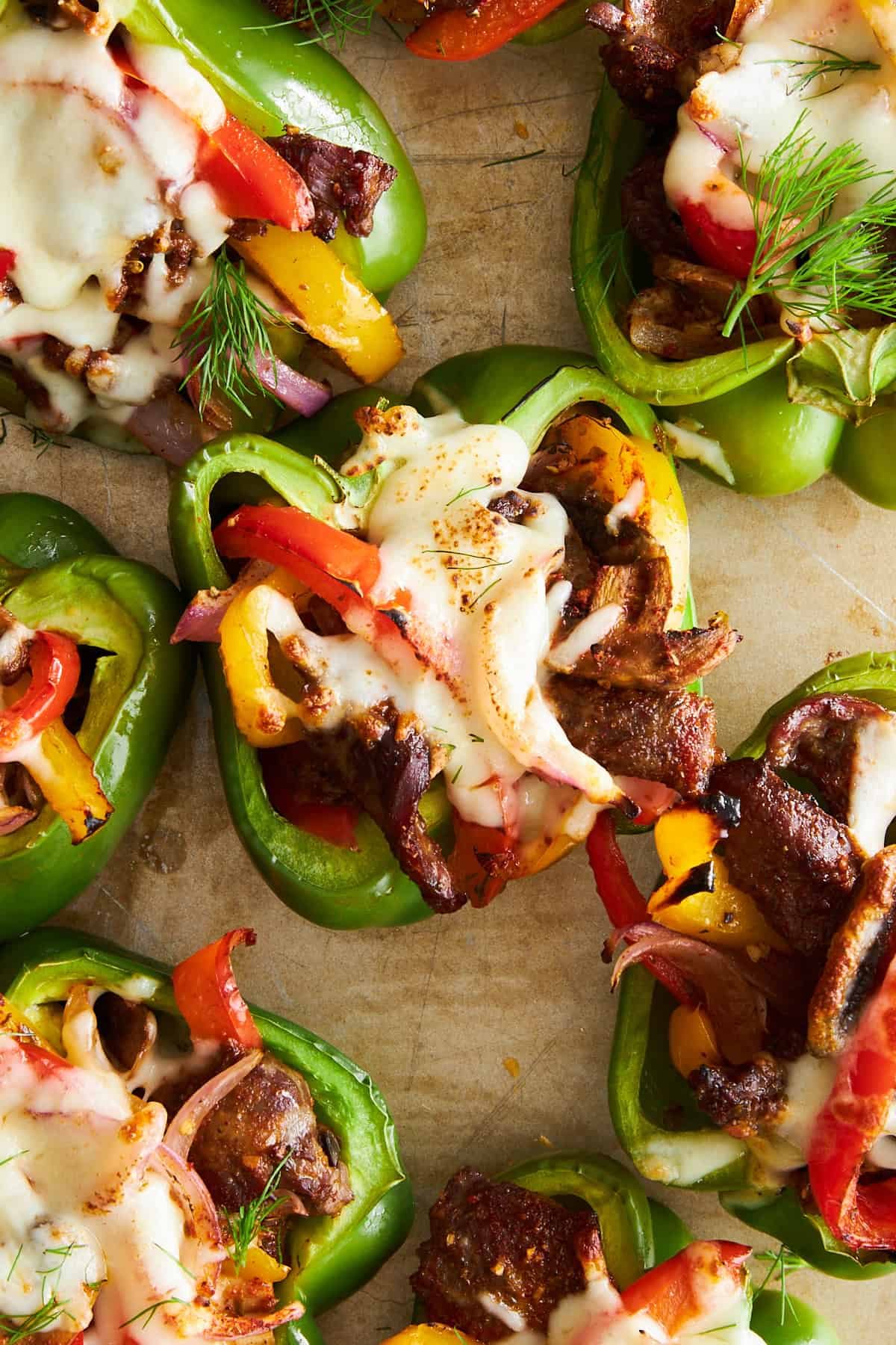 Philly cheesesteak stuffed peppers on a baking sheet.