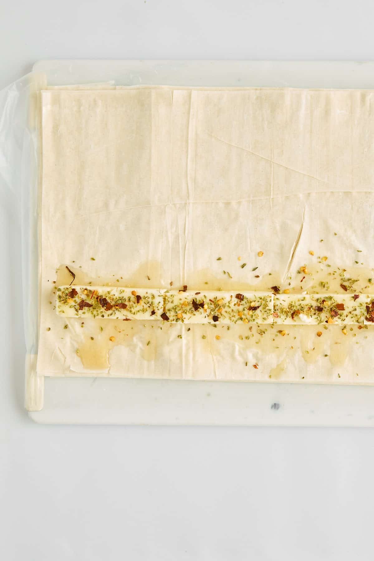 Feta pieces and hot honey on top of phyllo dough.