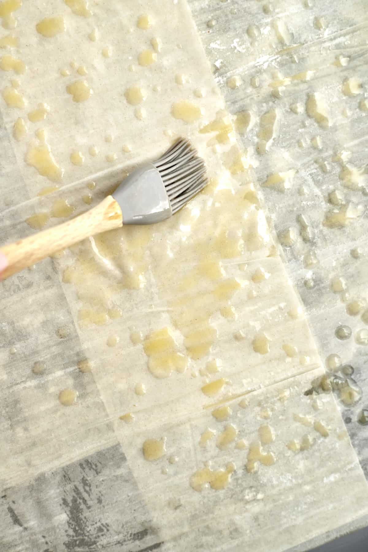 phyllo dough being brushed with melted butter