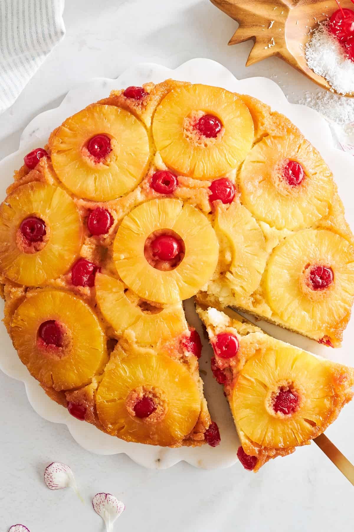 A slice of pineapple upside down cake being removed from a whole cake.