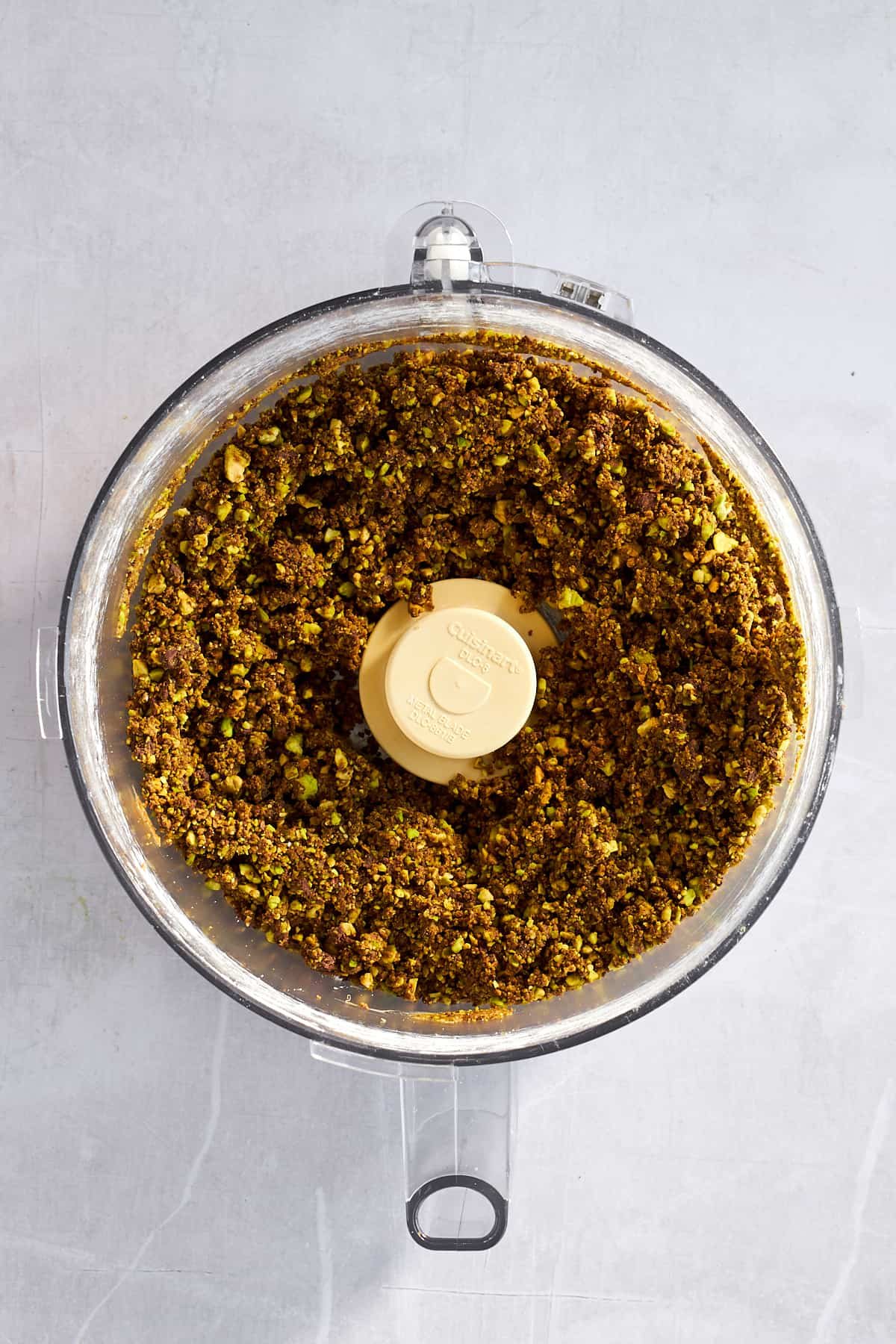 A chocolate and pistachio mixture in a food processor.