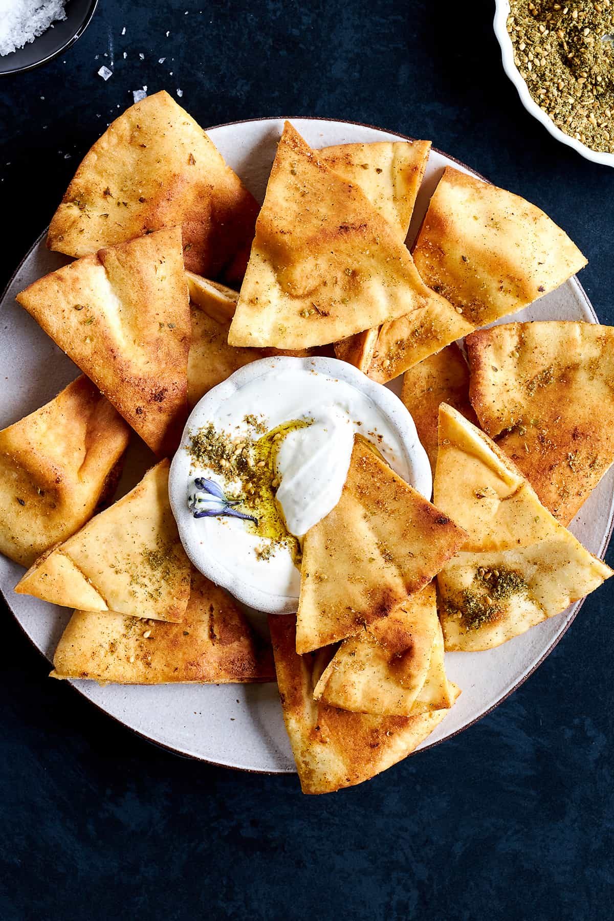 A platter of from-scratch pita chips with a silky dip in the center.