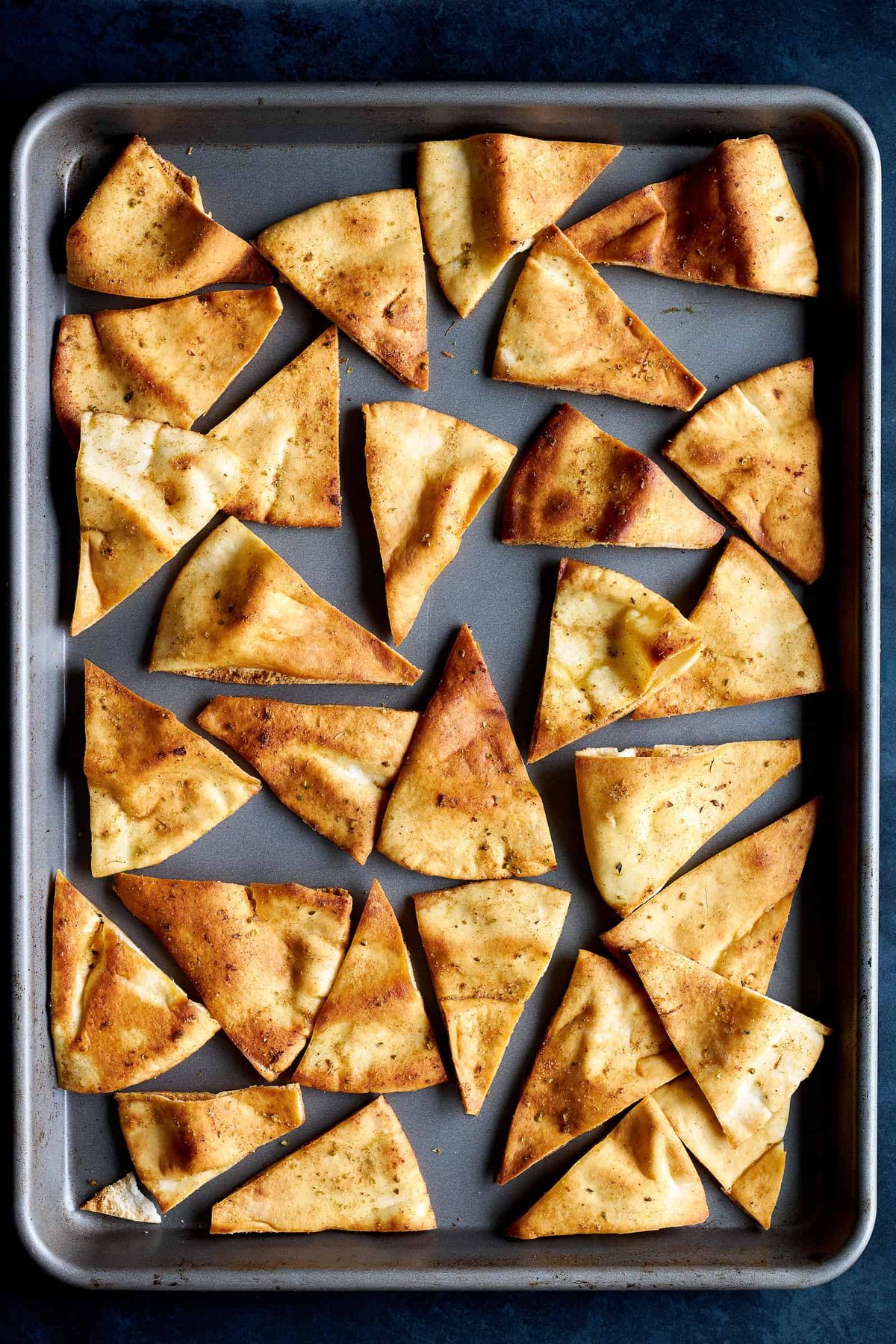 Baked pita chips on a baking sheet.