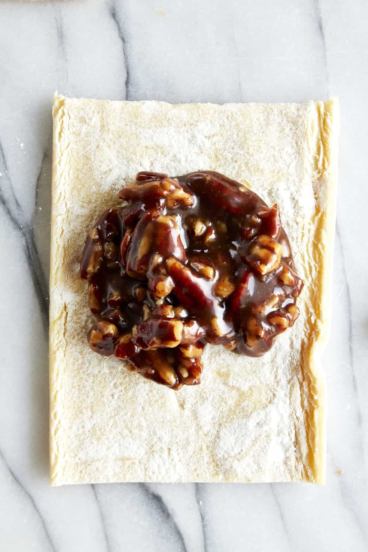 Pecan pie filling in the center of a puff pastry square.