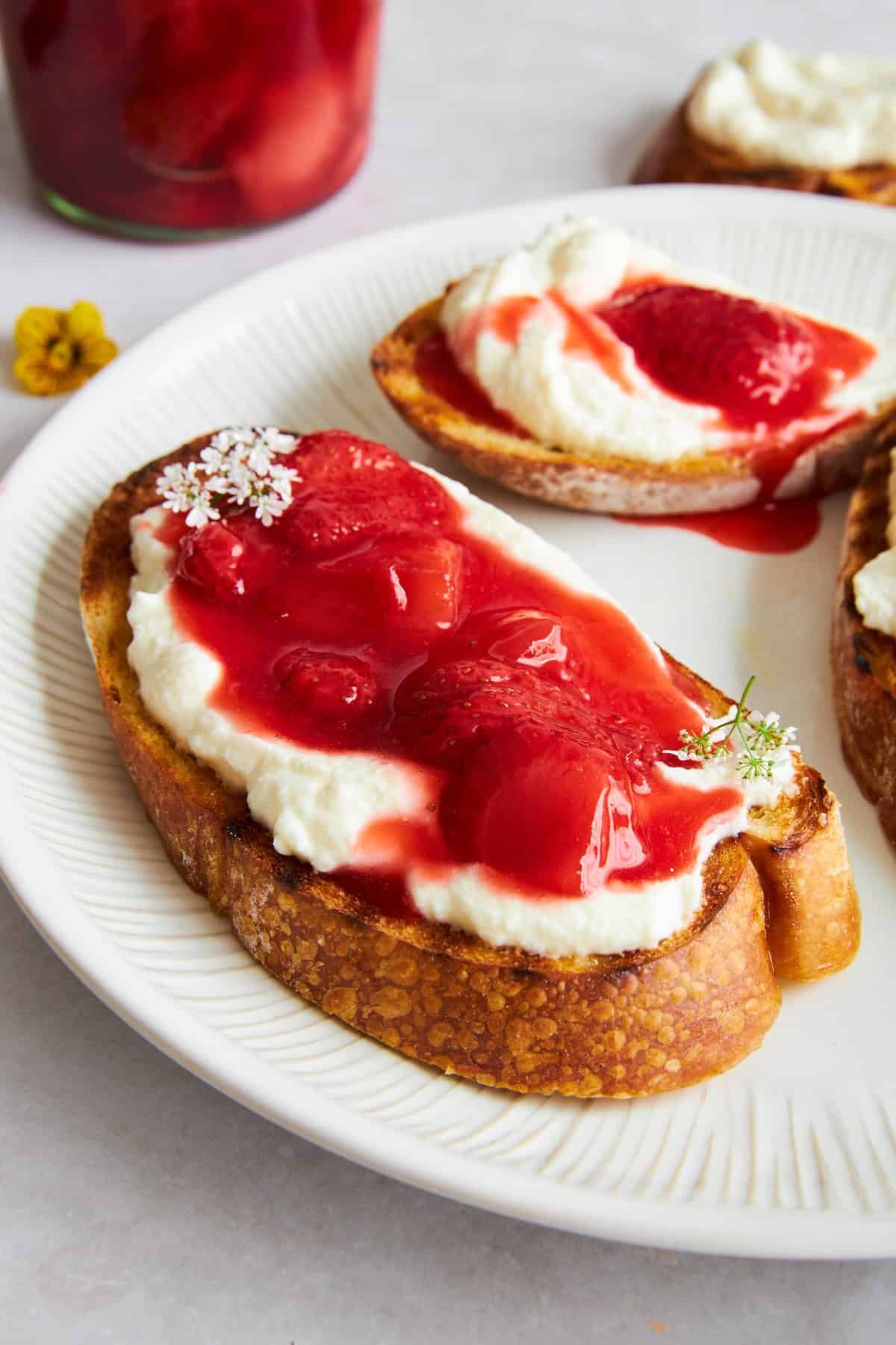 Strawberry ricotta toast on a plate.